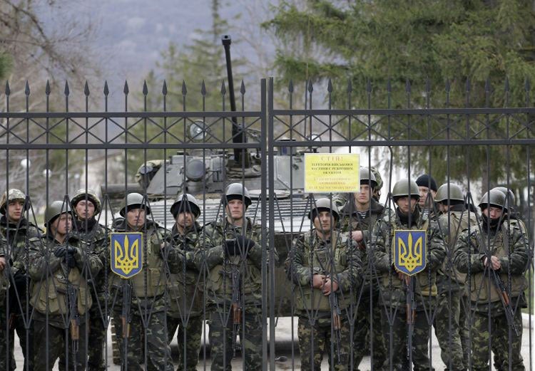 Ukrainian soldiers guard a gate of an infantry base in Privolnoye