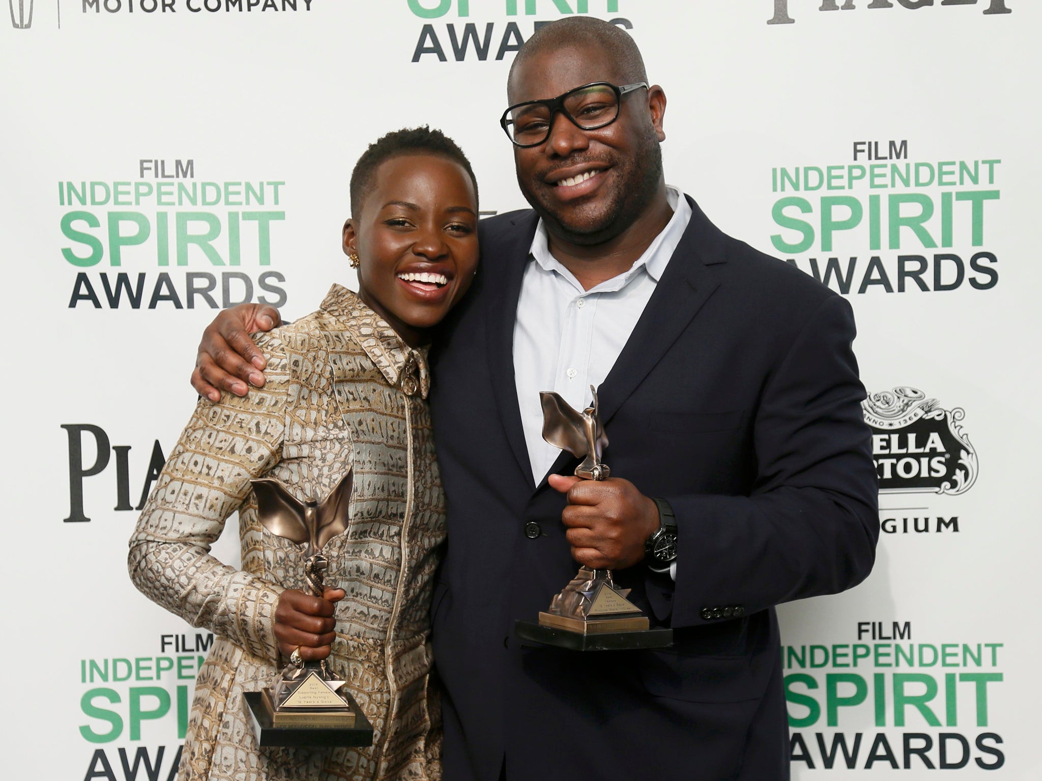 Actress Lupita Nyong'o and director Steve McQueen pose with their awards for 12 Years a Slave backstage at the 2014 Film Independent Spirit Awards in Santa Monica