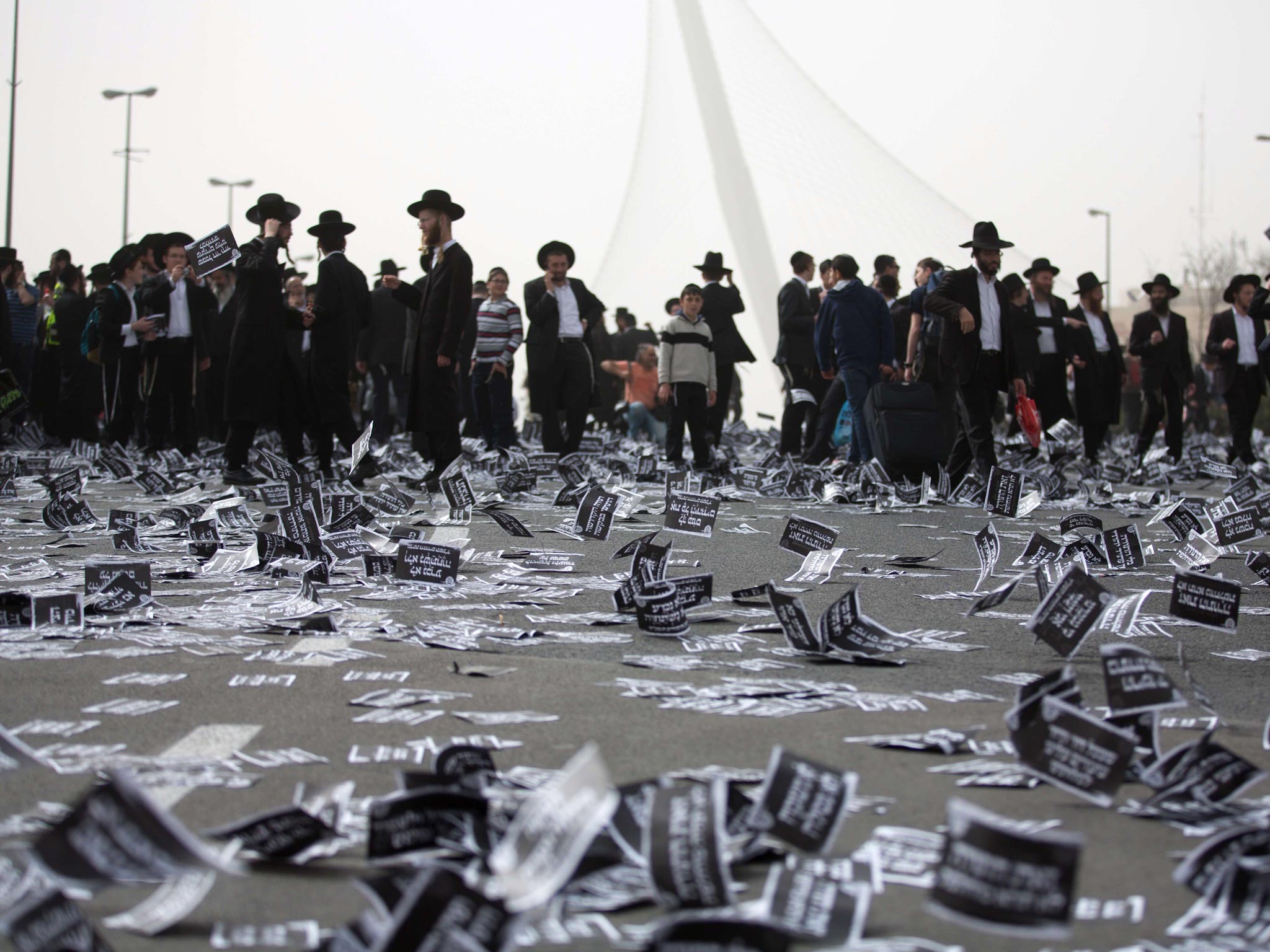 Ultra Orthodox Jews walk past flying leaflets as they gather along with hundreds of thousands in Jerusalem