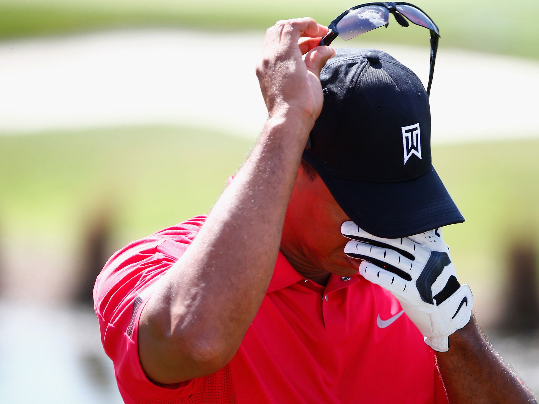 Tiger Woods grimaces with pain before his withdrawal from the Honda Classic on Sunday