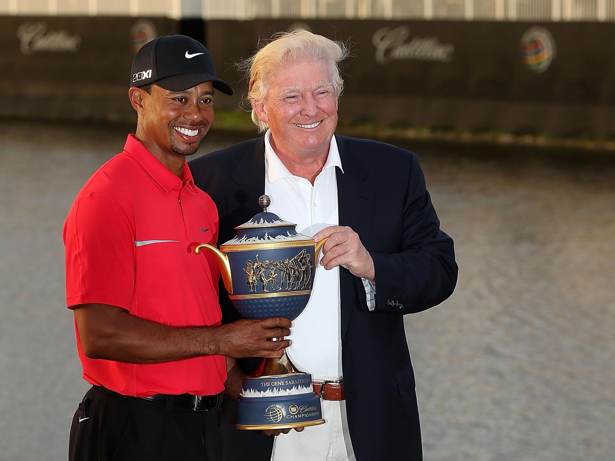 Donald Trump poses with Tiger Woods at Trump National Doral Miami Resort last year