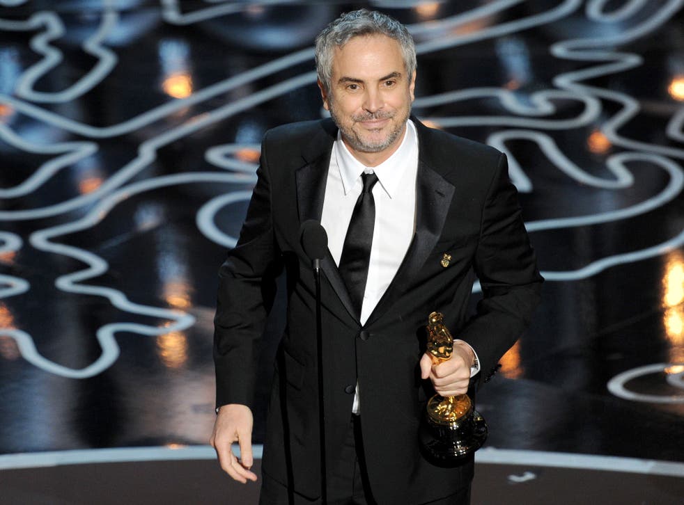 Gravity director Alfonso Cuaron collects his Oscar for Best Director