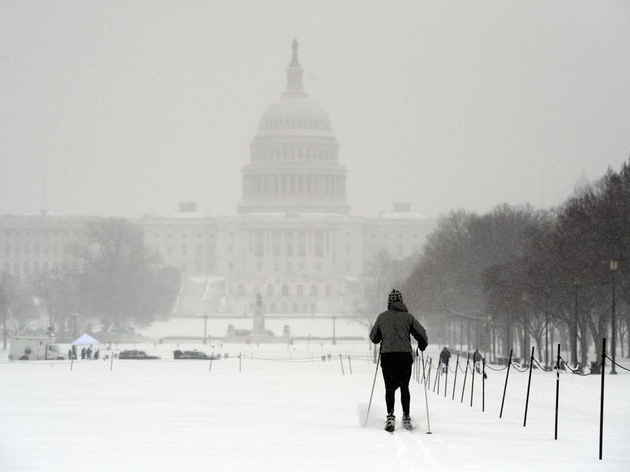 A man uses skis to make his way on the national mall during a snow storm in Washington, DC (AFP/Getty Images)