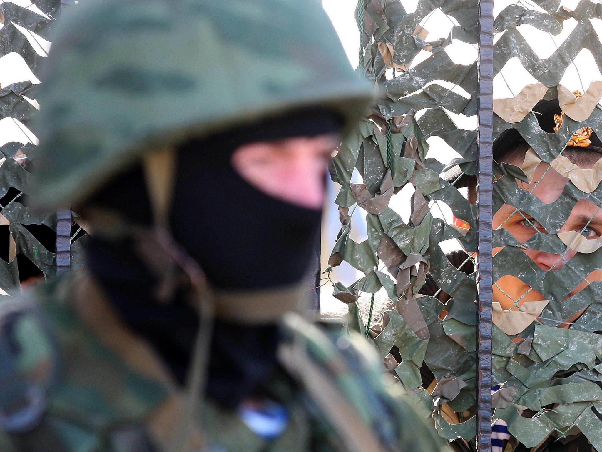 Armed man in military uniform, believed to be Russian, stands outside the territory of the Ukrainian naval headquarters