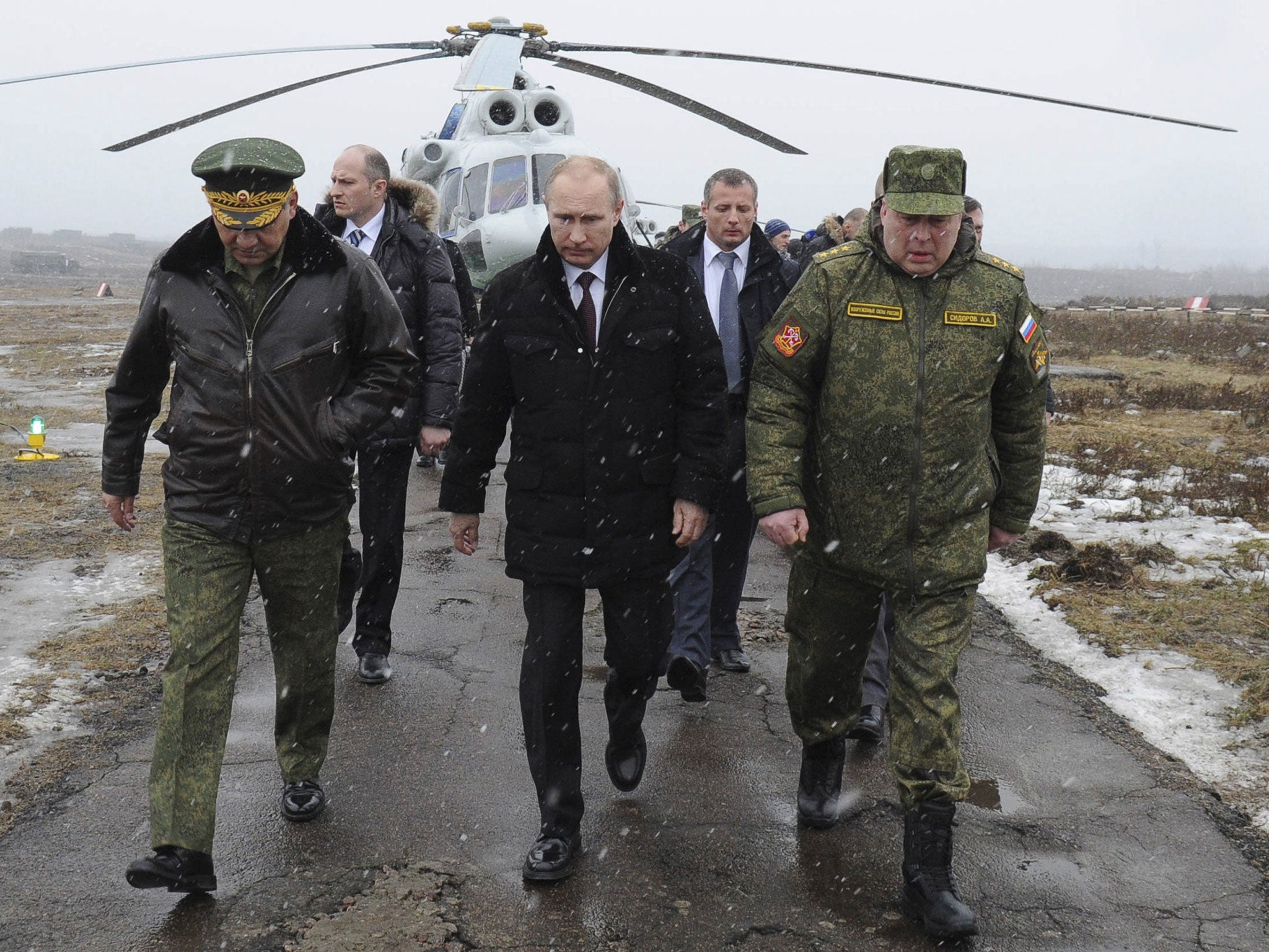 Russia's President Vladimir Putin, accompanied by Russian Defence Minister Sergei Shoigu (front left), walks to watch military exercises upon his arrival at the Kirillovsky firing ground in the Leningrad region