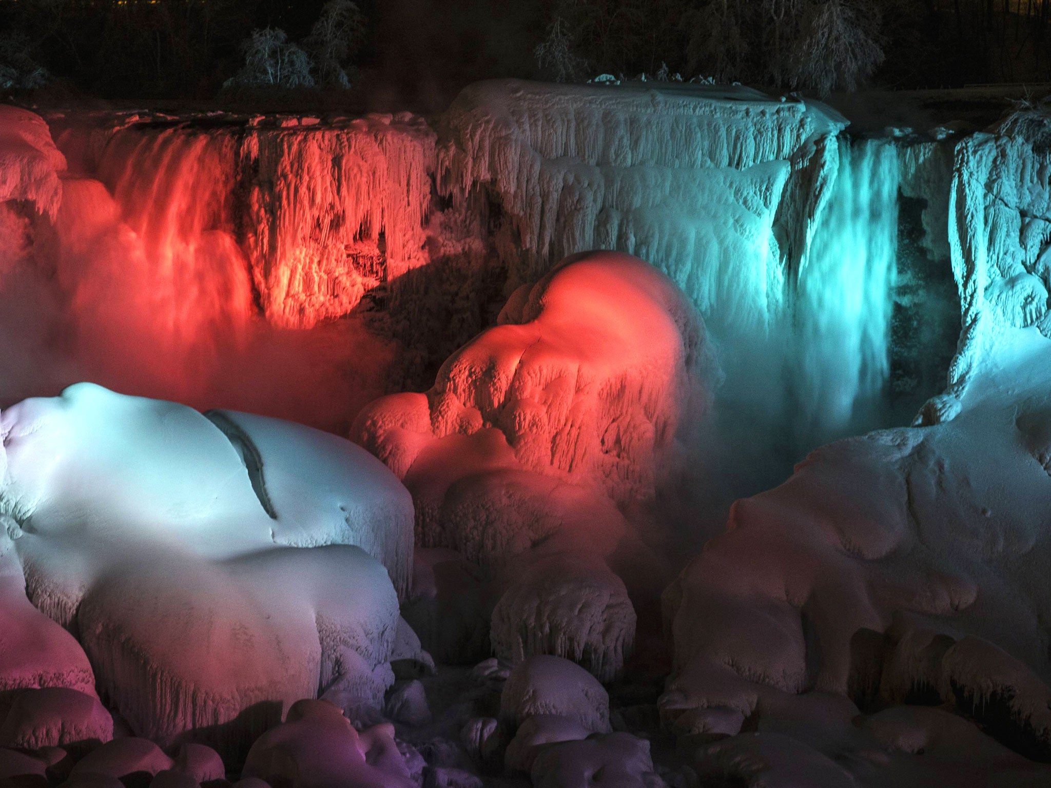 A partially frozen American Falls is seen lit by lights during sub freezing temperatures in Niagara Falls, Ontario