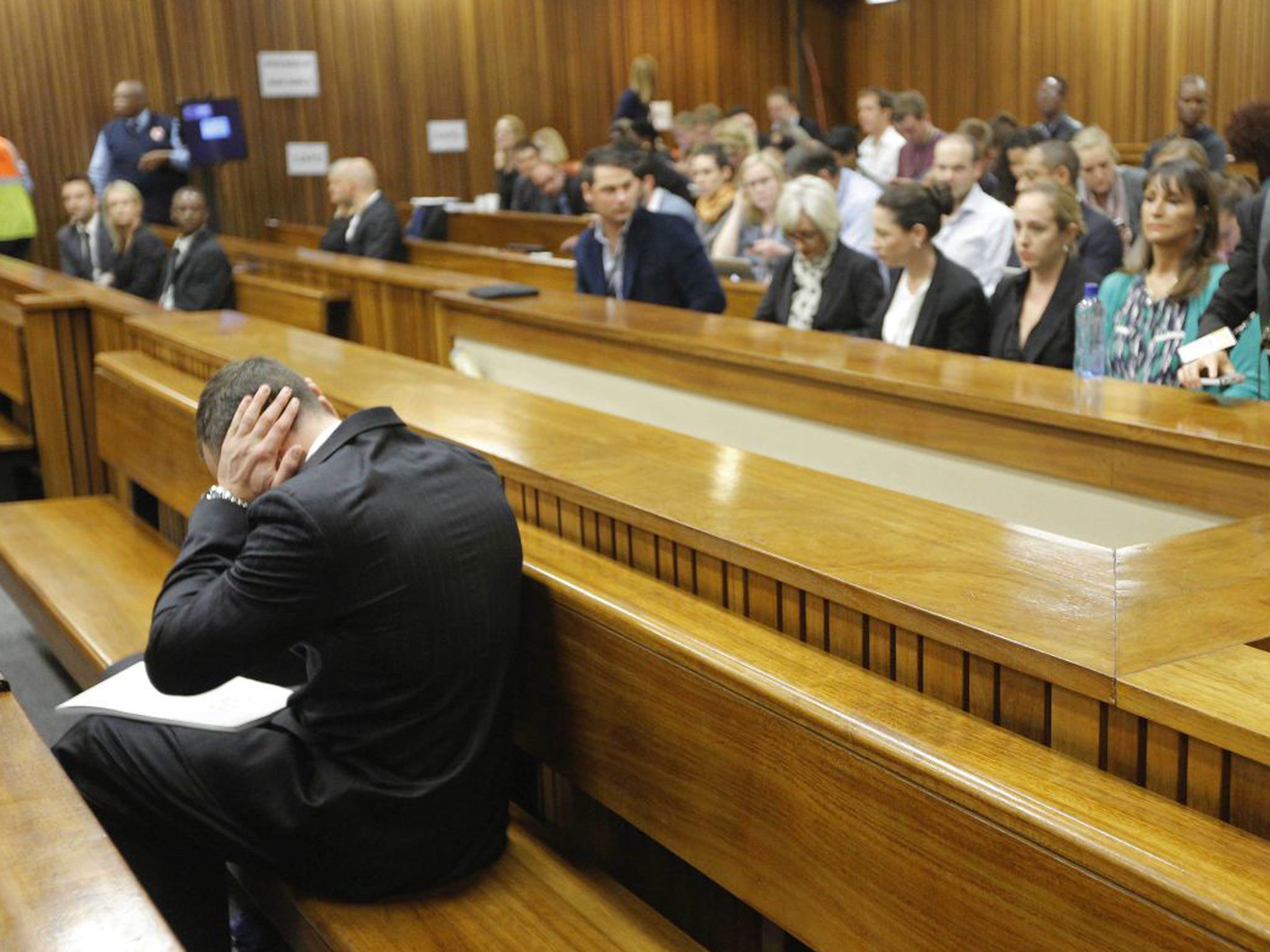 Oscar Pistorius blocks his ears inside the high court on the second day of his trial in Pretoria, South Africa