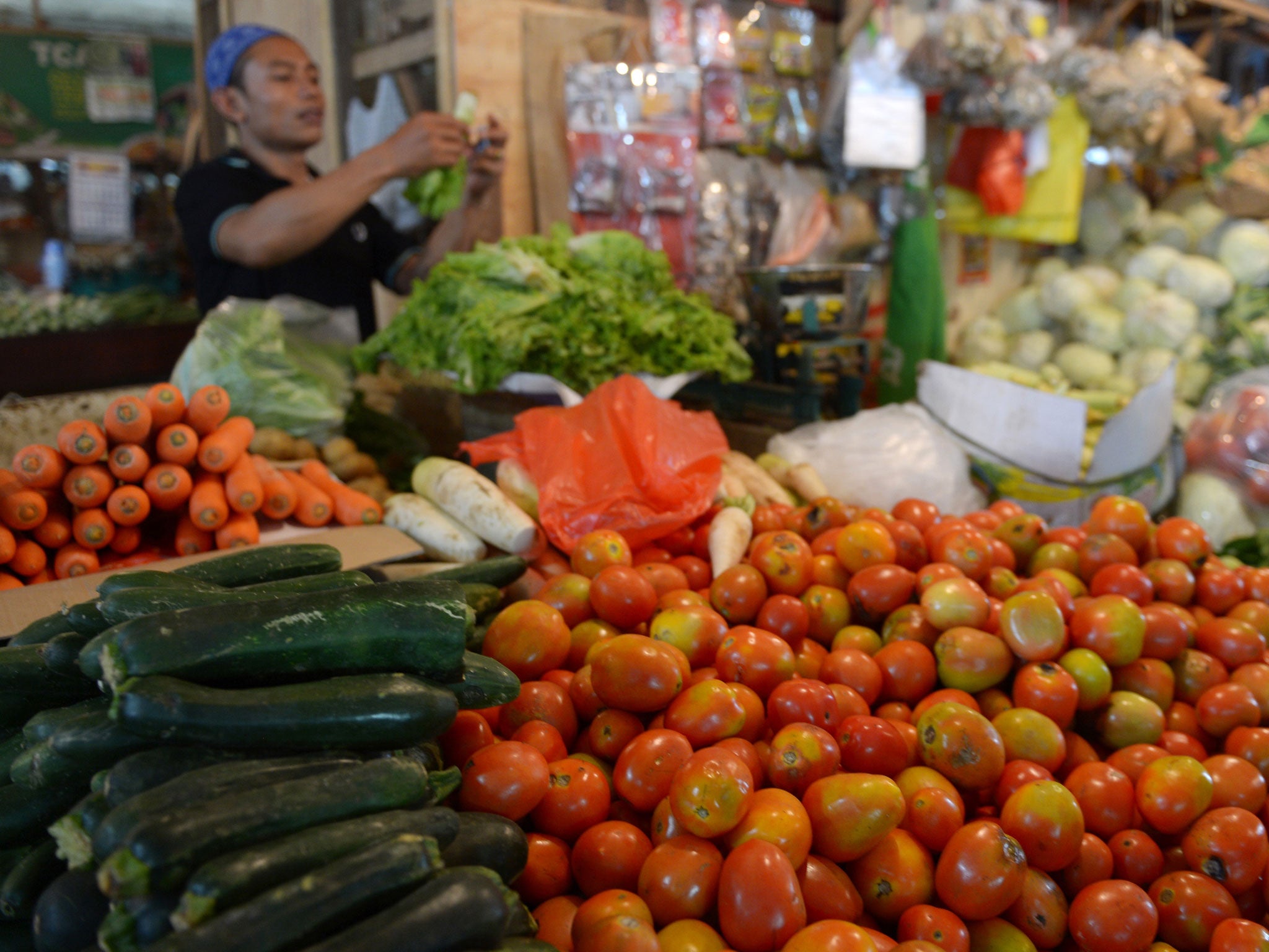 An Indonesian vendor sells vegetables in Jakarta.