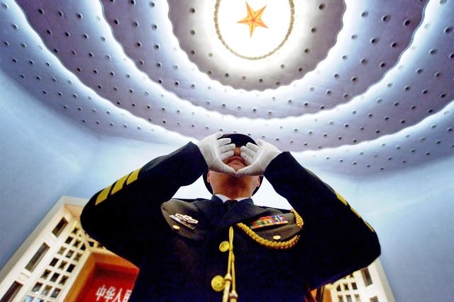Top brass: an officer in the Chinese People’s Liberation Army practises to conduct the military band before the opening session of the 12th National People’s Congress in Beijing