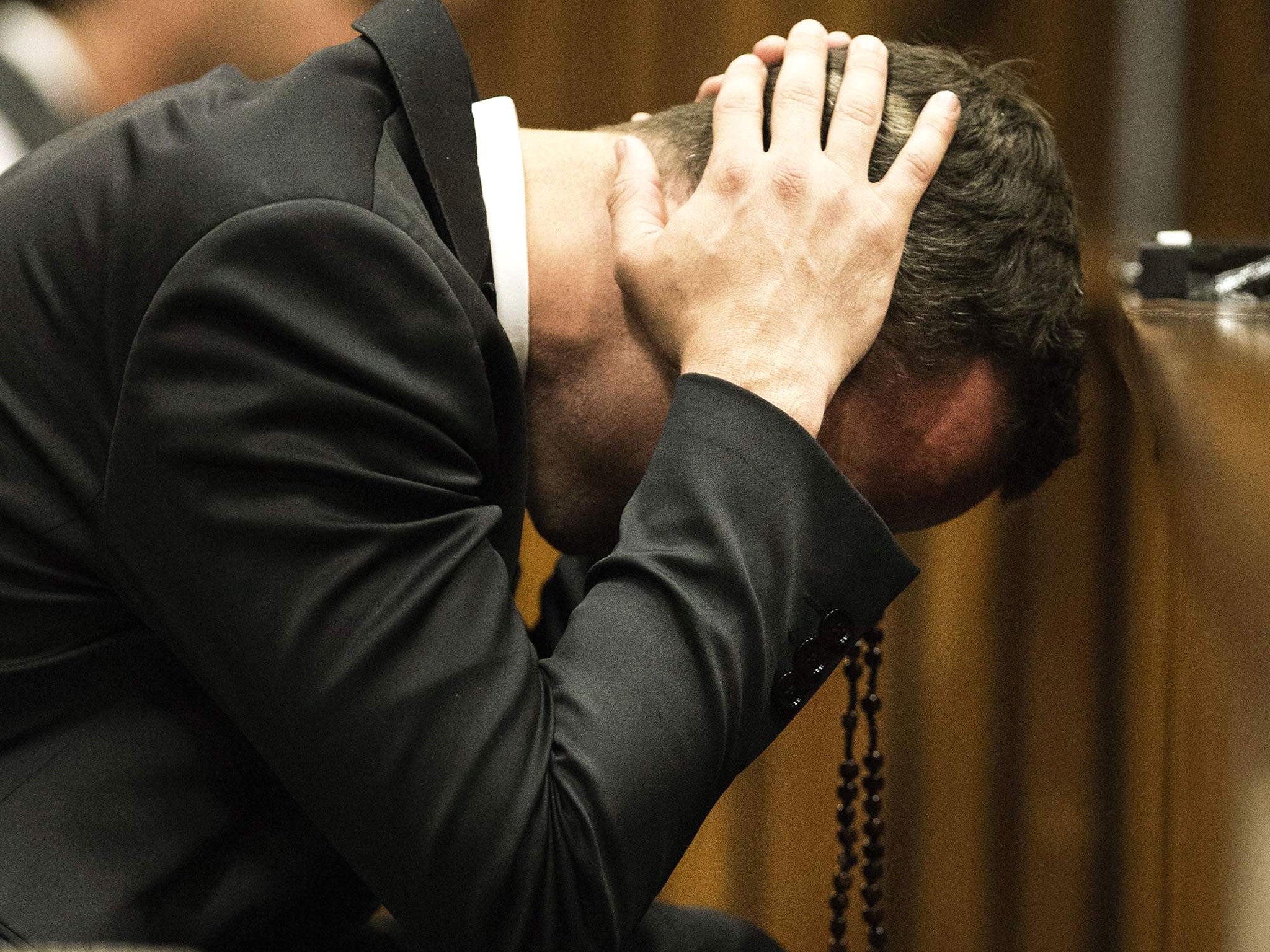 Oscar Pistorius puts his hands to his head while a witness testifies and speaks about the morning of the shooting of his girlfriend Reeva Steenkamp