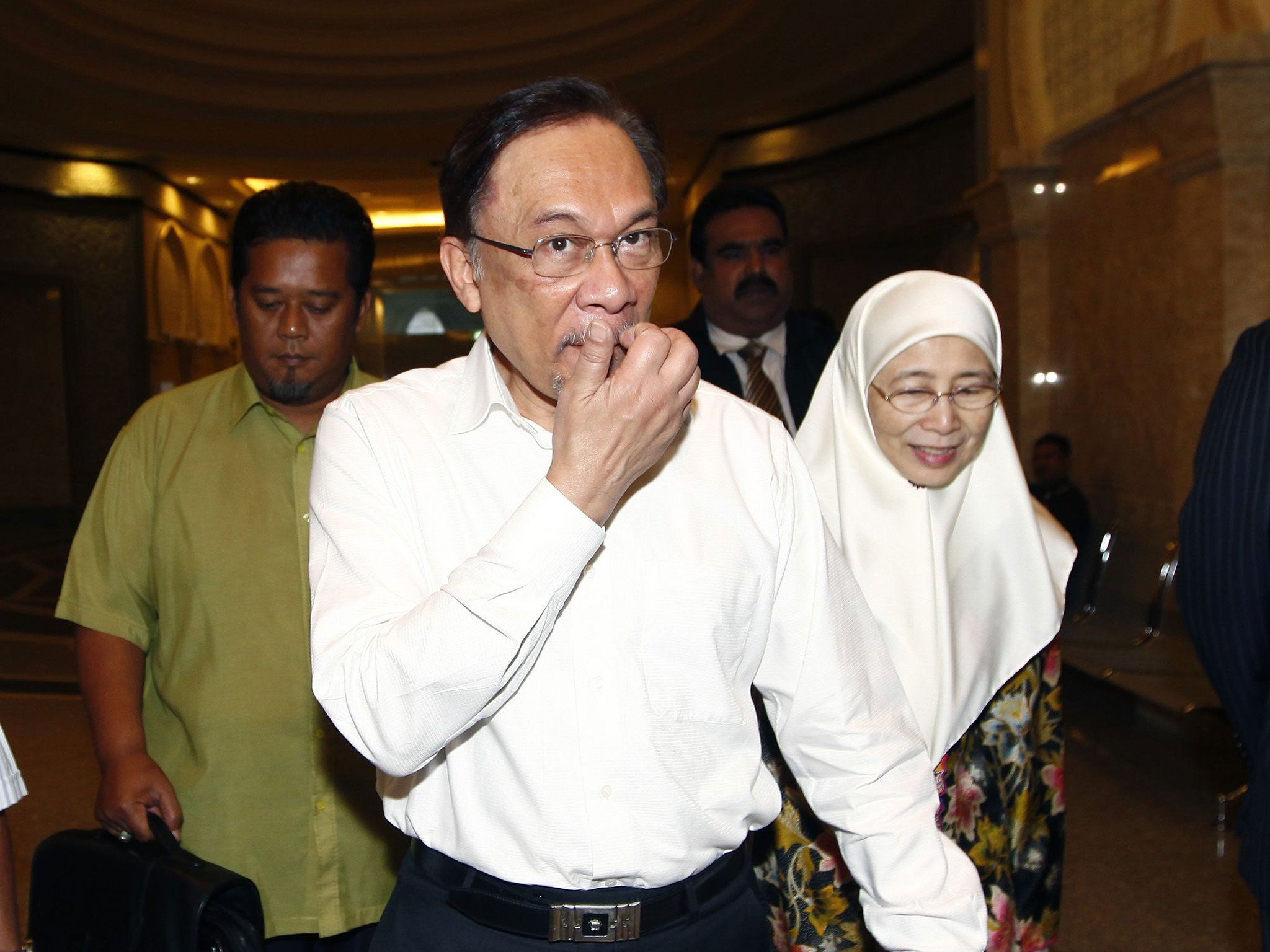 Malaysian opposition leader Anwar Ibrahim (C) and his wife Wan Azizah arrive at a court house in Putrajaya March 7, 2014.
