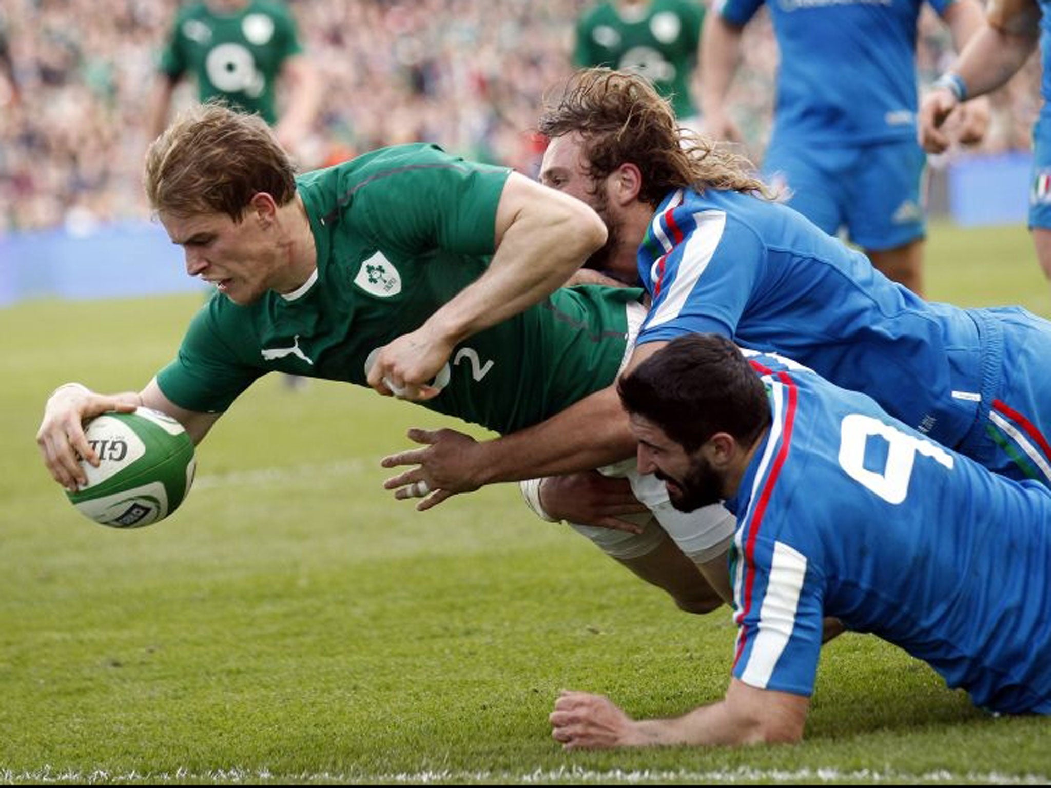 Ireland's Andrew Trimble scores a try despite being tackled by Italy's Tito Tebaldi, right, and Joshua Raffaele Furno during their Six Nations Rugby Union international match at the Aviva Stadium, Dublin, Ireland