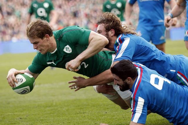 Ireland's Andrew Trimble scores a try despite being tackled by Italy's Tito Tebaldi, right, and Joshua Raffaele Furno during their Six Nations Rugby Union international match at the Aviva Stadium, Dublin, Ireland