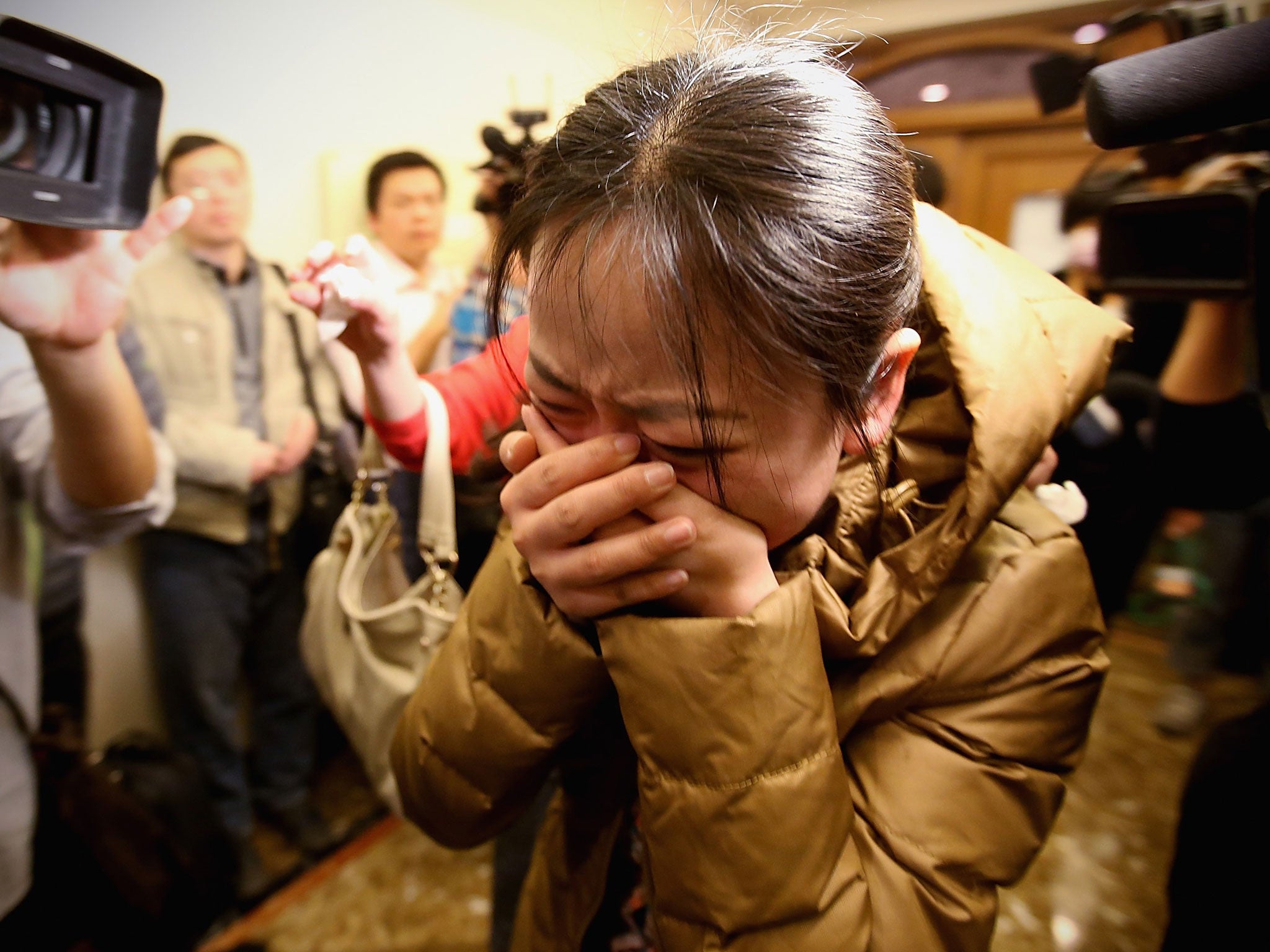 A relative of a passenger onboard Malaysia Airlines flight MH370 cries out at a local hotel where families are gathered