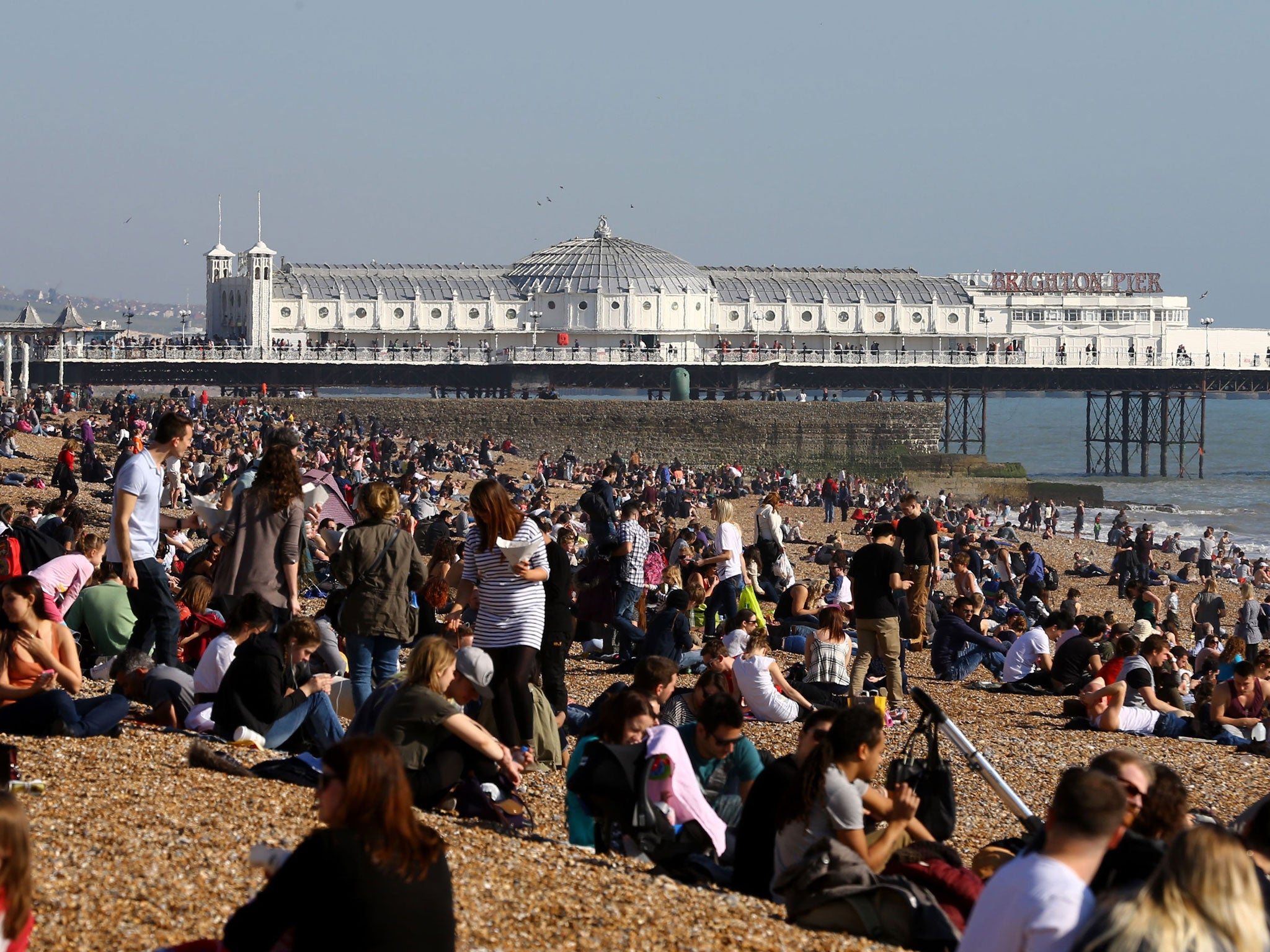 Crowds on the beach in Brighton, East Sussex, as record temperatures greeted many Britons this morning (PA)