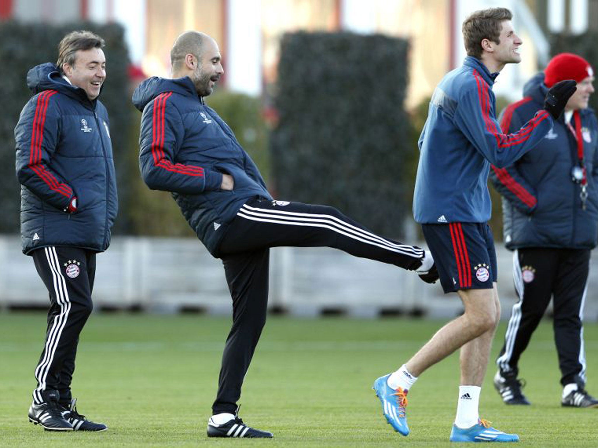 Pep Guardiola gives Thomas Müller a friendly kick in training