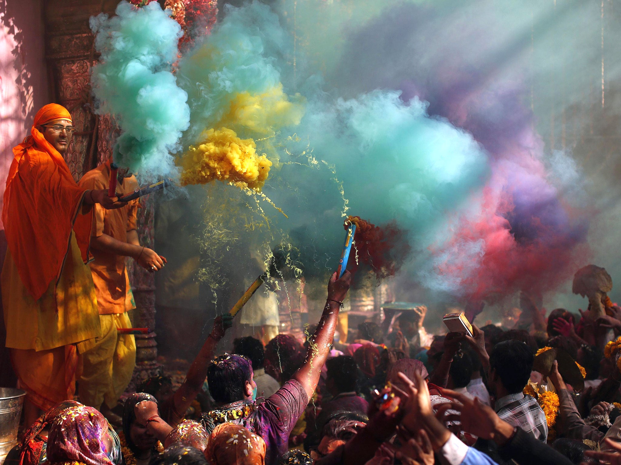 Colourful smoke rises as Hindu priests throws coloured powder at the devotees during Holi celebrations at Bankey Bihari temple in Vrindavan, in the northern Indian state of Uttar Pradesh