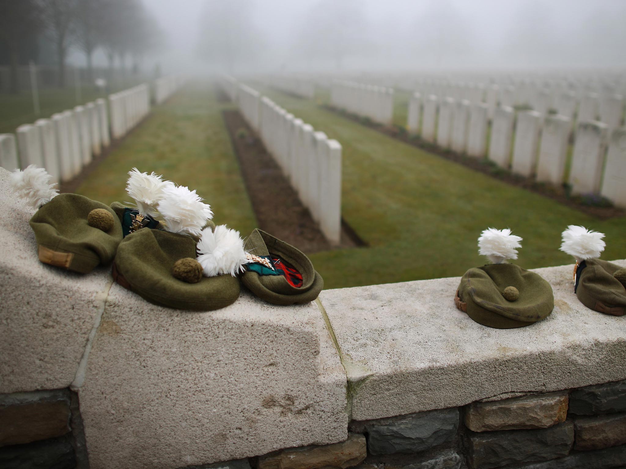 Military Tam O Shanter caps belonging to soldiers of The 2nd Battalion The Royal Regiment of Scotland are placed on the wall of Loos British Cemetery