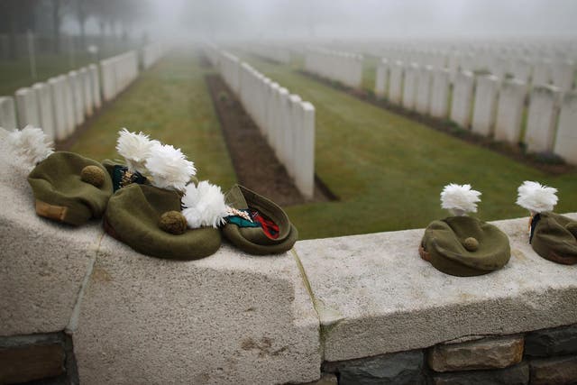 Military Tam O Shanter caps belonging to soldiers of The 2nd Battalion The Royal Regiment of Scotland are placed on the wall of  Loos British Cemetery 