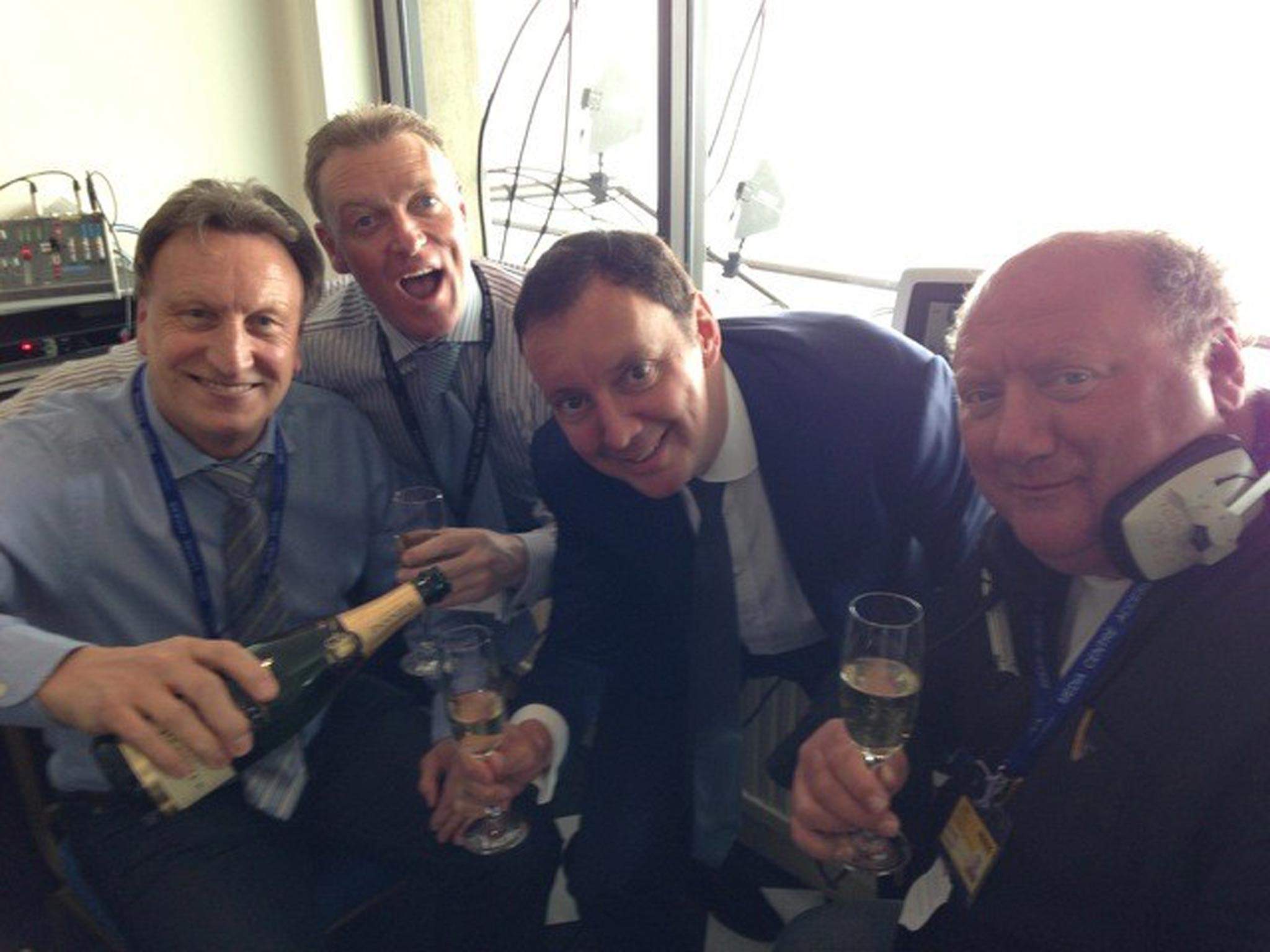 Neil Warnock pour the bubbly, while Simon Clare and David Stevens of Coral and Alan Brazil lift their glasses