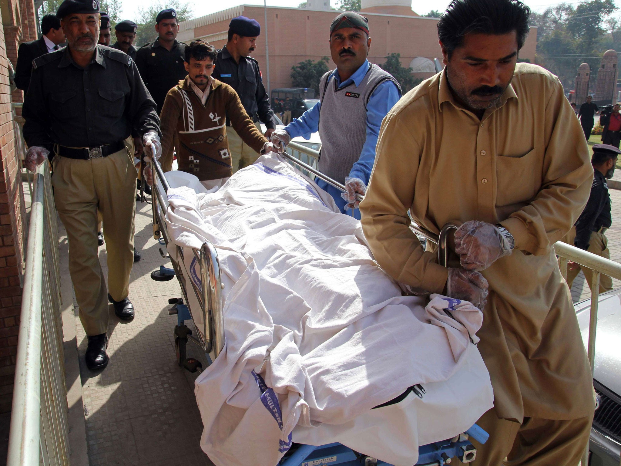 Pakistani paramedics and policemen move the body of a rape victim from a hospital in Multan on March 14, 2014. A Pakistani teenager died on March 14 after setting herself on fire after a court dropped charges against four men accused of raping her, police
