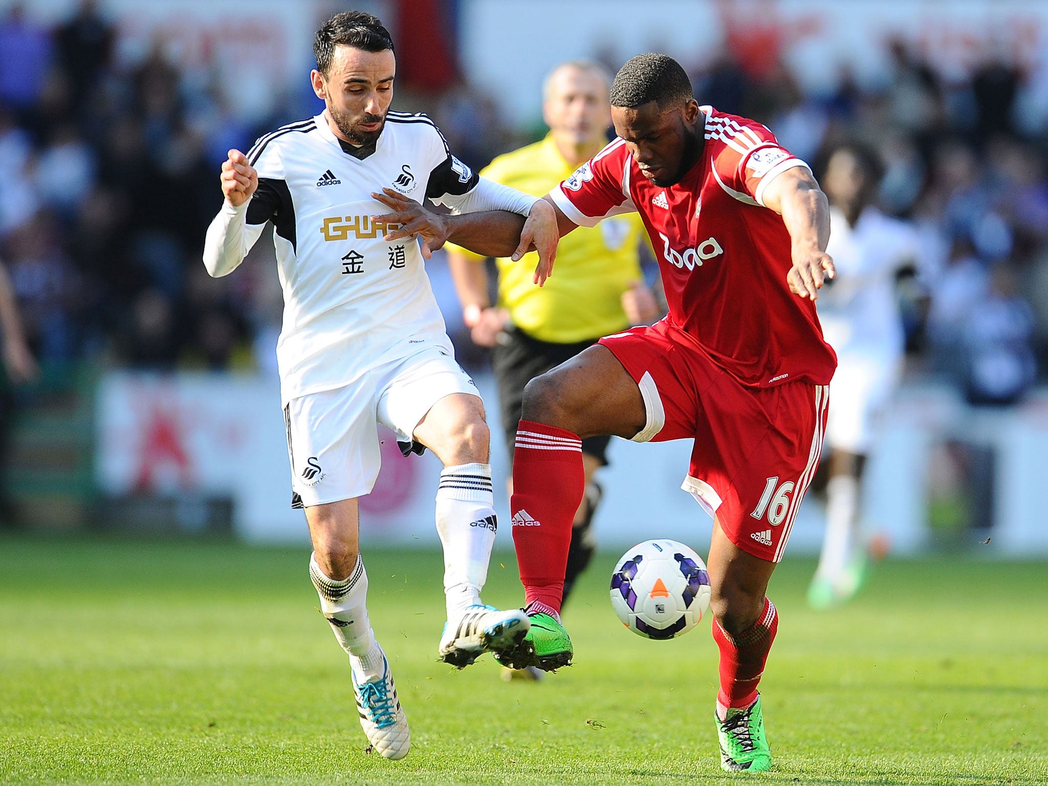 Leon Britton of Swansea City and Victor Anichebe of West Bromwich Albion