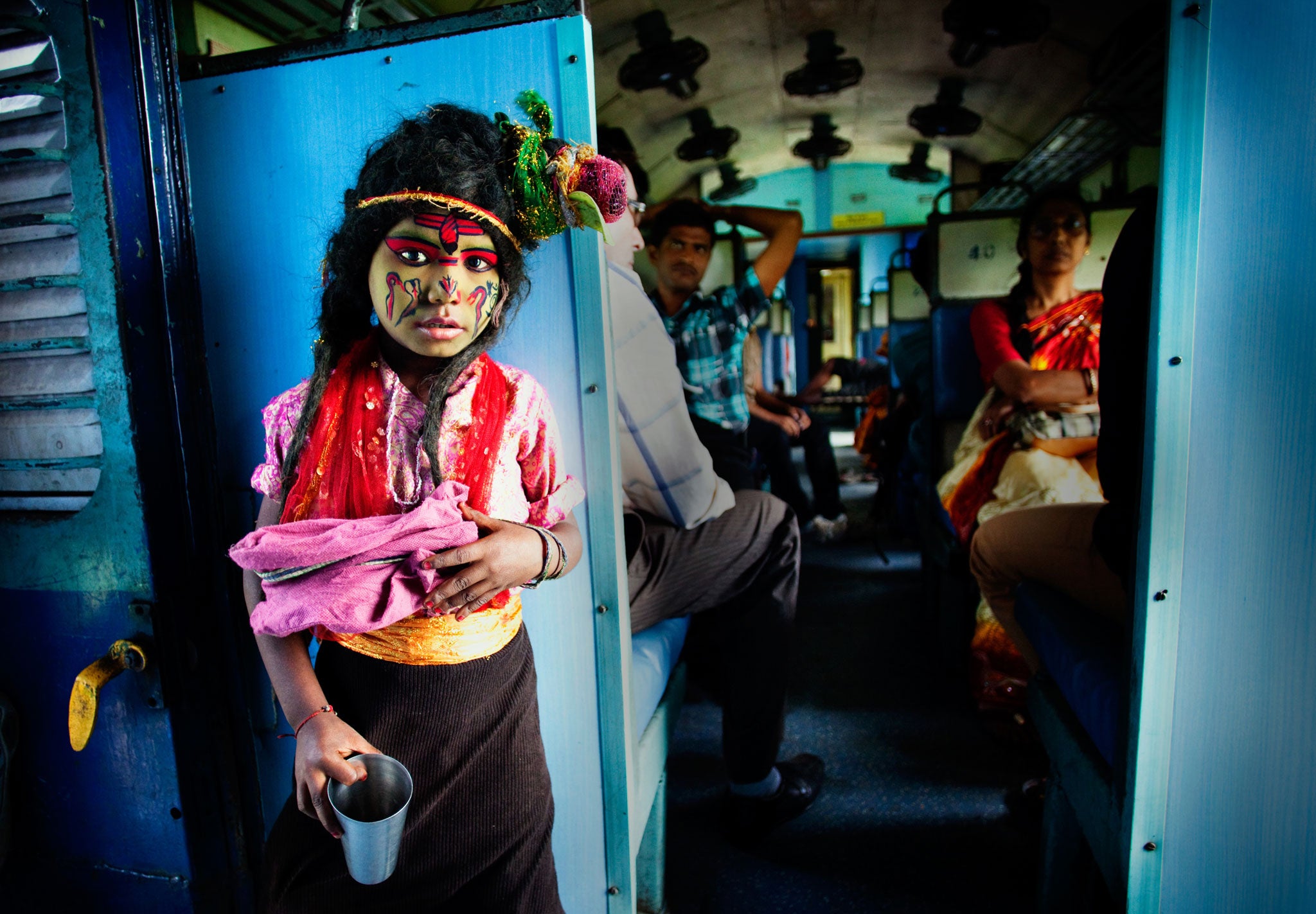 I was on Durga Puja Festival vacation, travelling on a local train. A boy was singing devotional song and begging for alms. He was guised as a Hindu god, Lord Shiva. This is a common view in Indian trains but this boy was charming, bright and did have a m