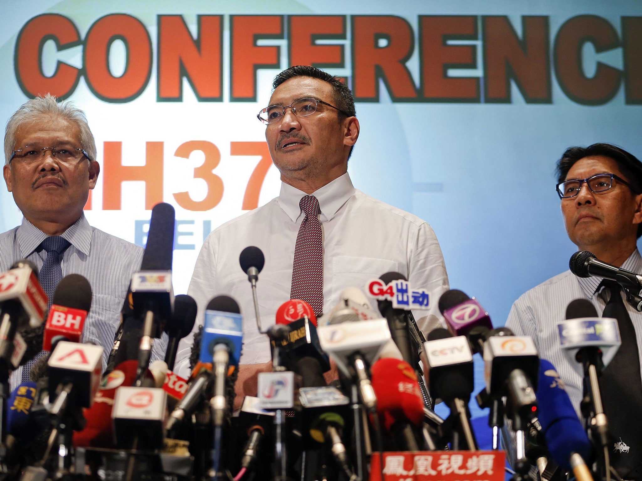 Malaysia's acting Transport Minister Hishammuddin Hussein (C) is accompanied by Deputy Foreign Minister Hamzah Zainudin (L) and Department of Civil Aviation's Director General Azharuddin Abdul Rahman as he addresses reporters about the missing Malaysia Ai