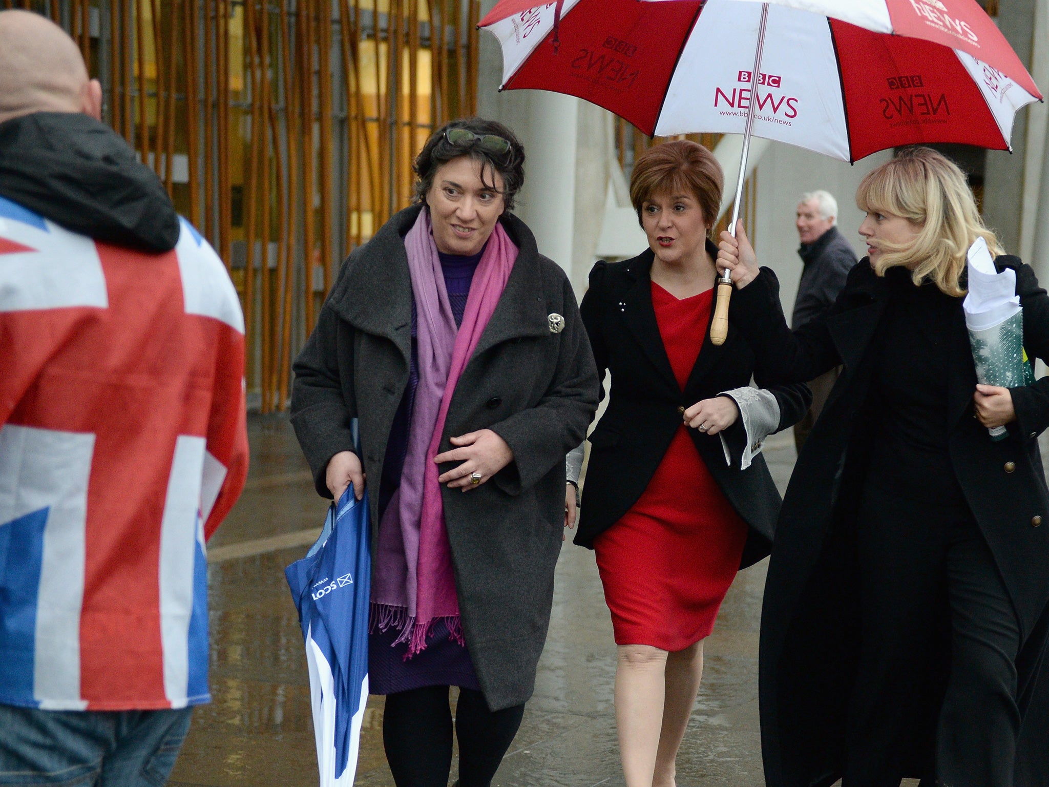 Stormy days on the EU? Deputy First Minister Nicola Sturgeon walks past a man draped in a Union Flag outside the Scottish Parliament (Getty)