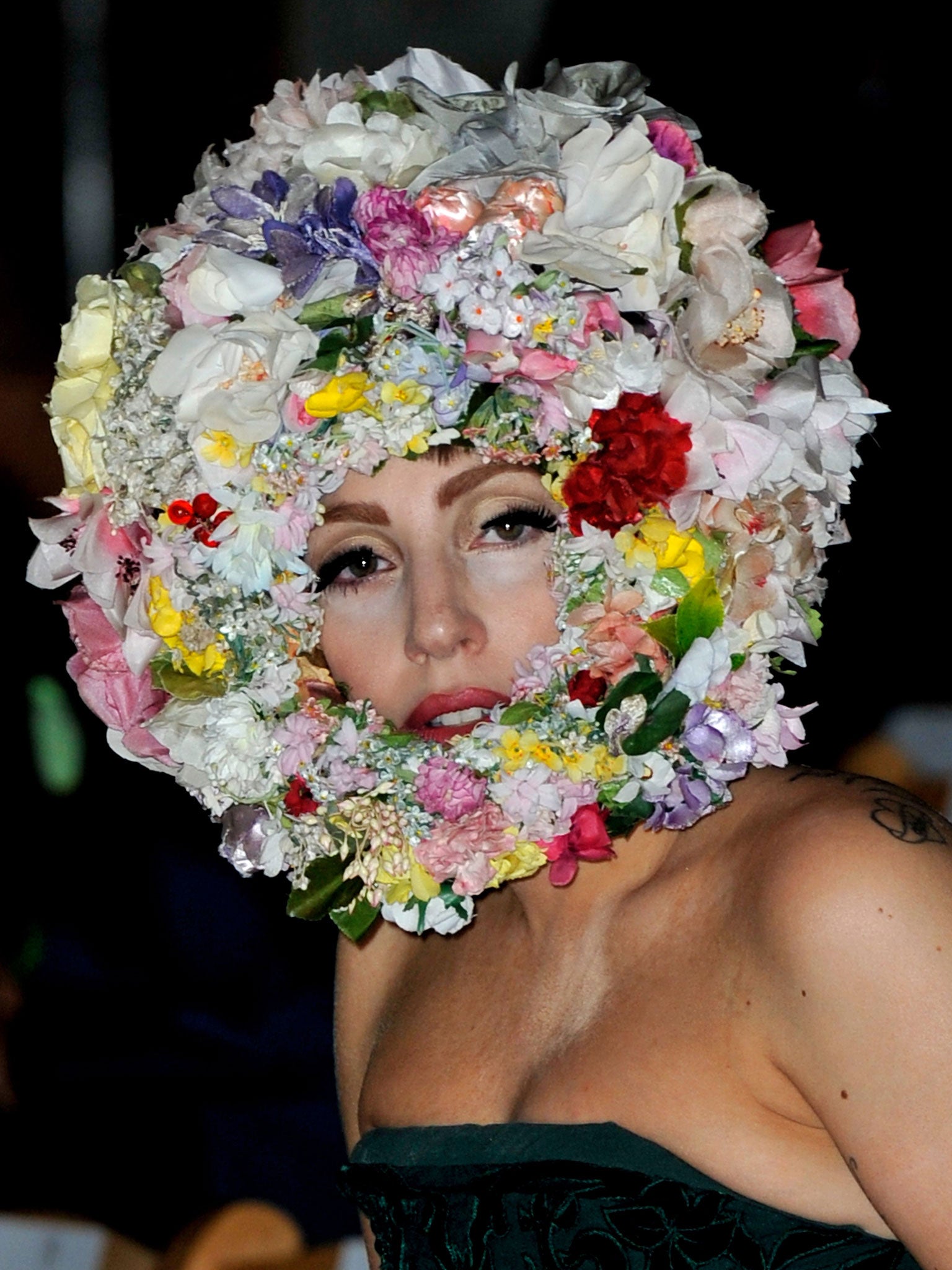 A mane of flowers frames Lady Gaga's face as she sits in the front row for Philip Treacy's show at London Fashion Week, S/S 2013