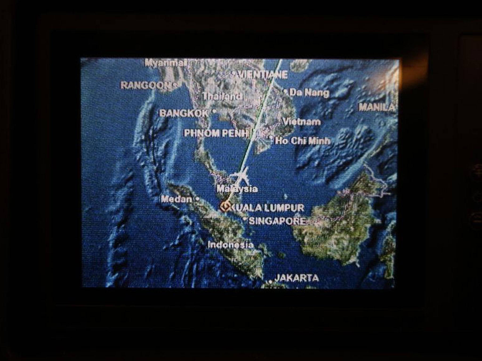 A screen on board Malaysia Airlines Boeing 777-200ER flight MH318 shows the plane's flight path as it cruises over the South China Sea from Kuala Lumpur towards Beijing at approximately the same point when flight MH370 lost contact with air traffic contro