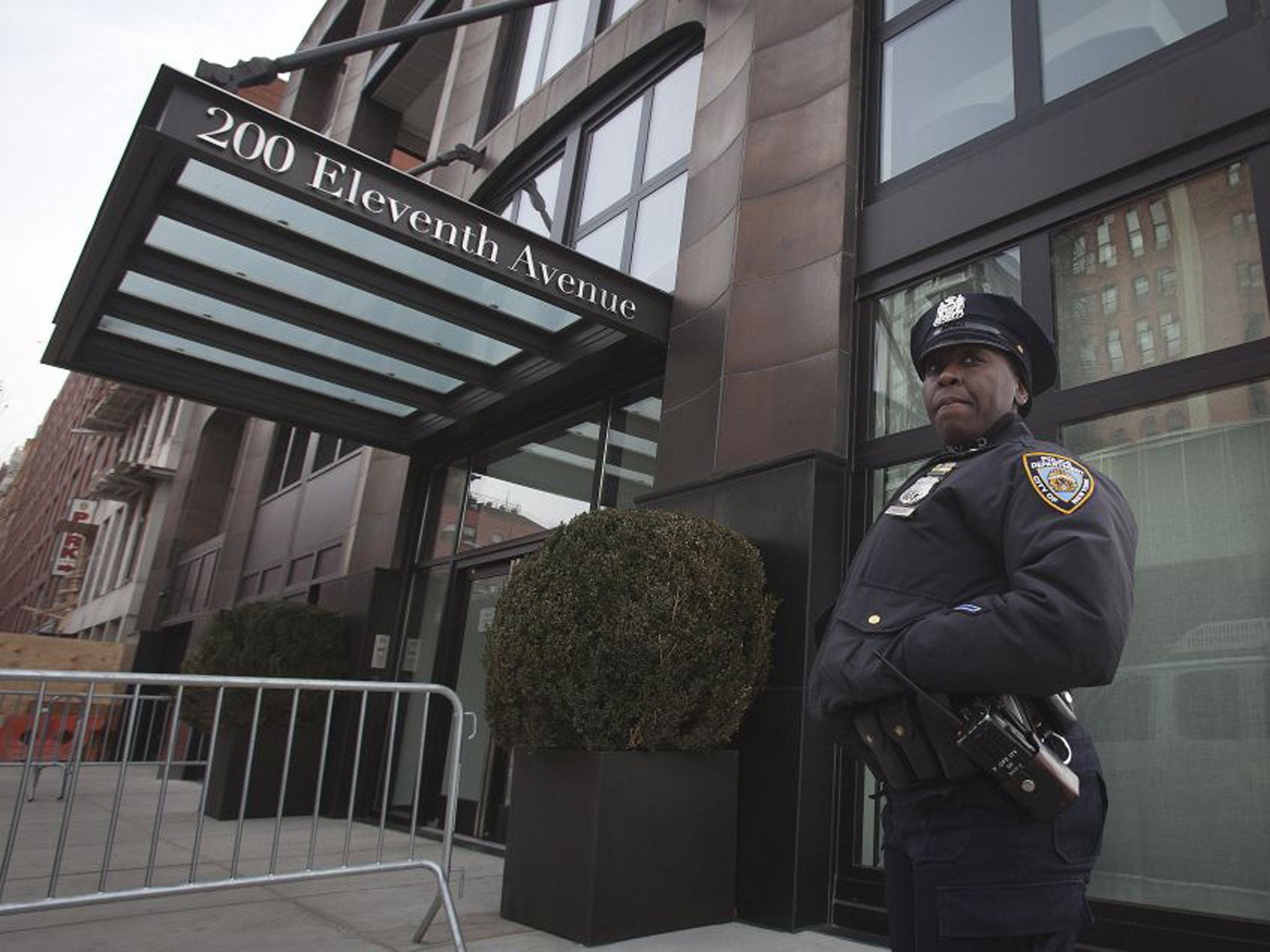 A policeman stands guard outside designer L’Wren Scott’s home in New York