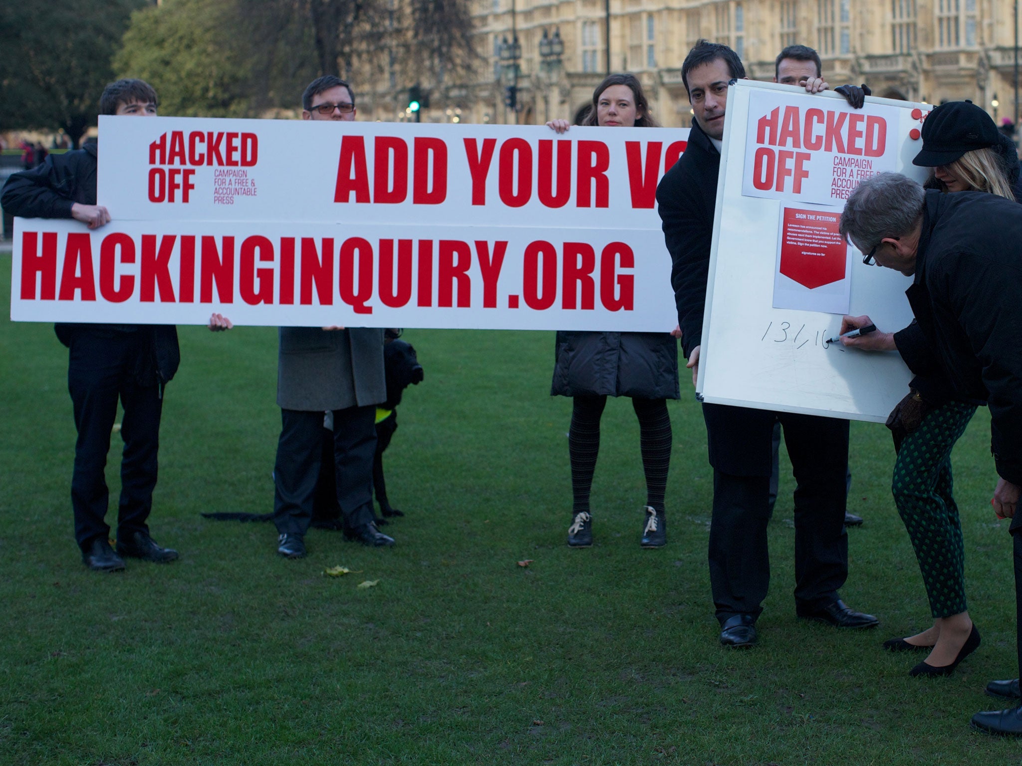 Members of the Hacked Off Campaign staging a photocall in 2012 outside Westminster to illustrate how many people have signed the petition for a free but accountable press
