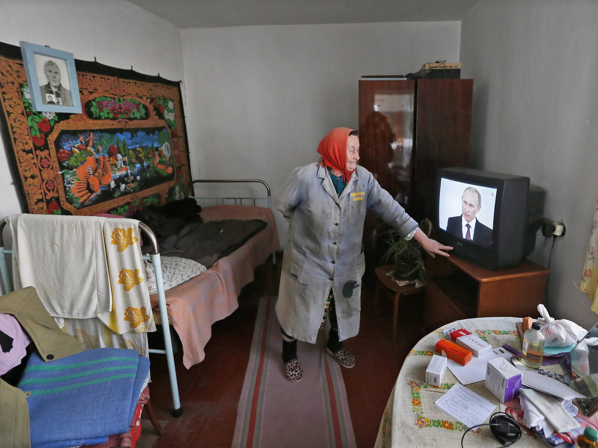 A Crimean woman watches Vladimir Putin address the Russian Federal Assembly