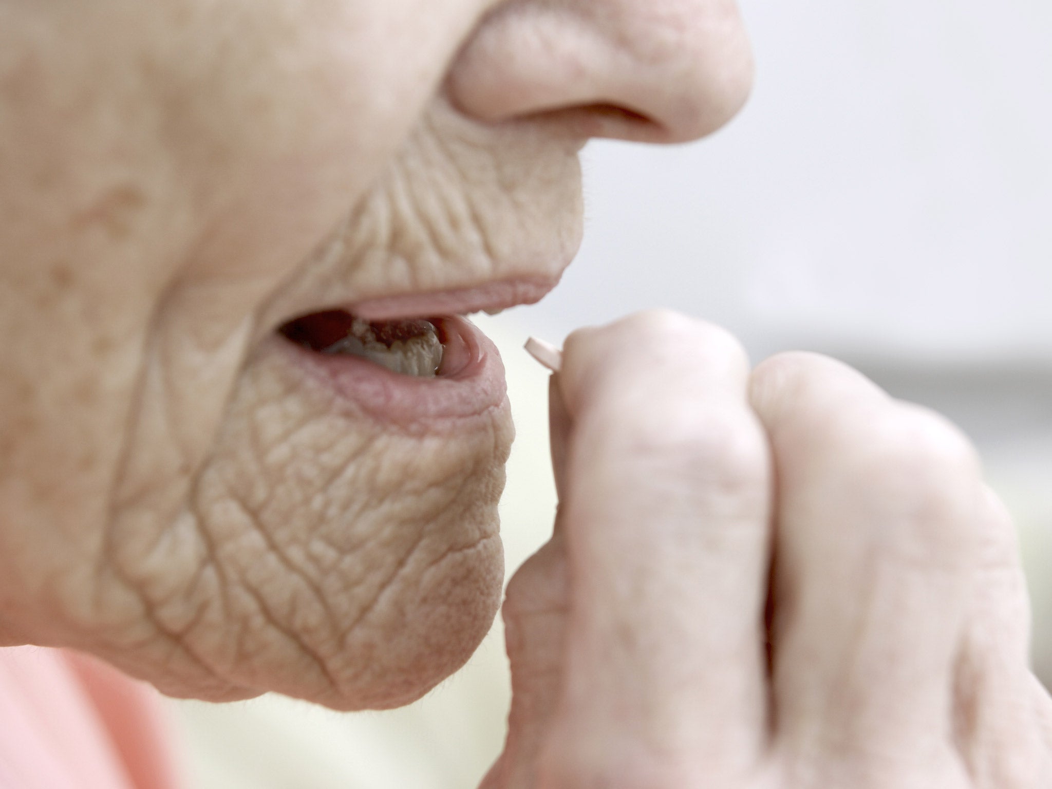 An elderly woman takes statin medication