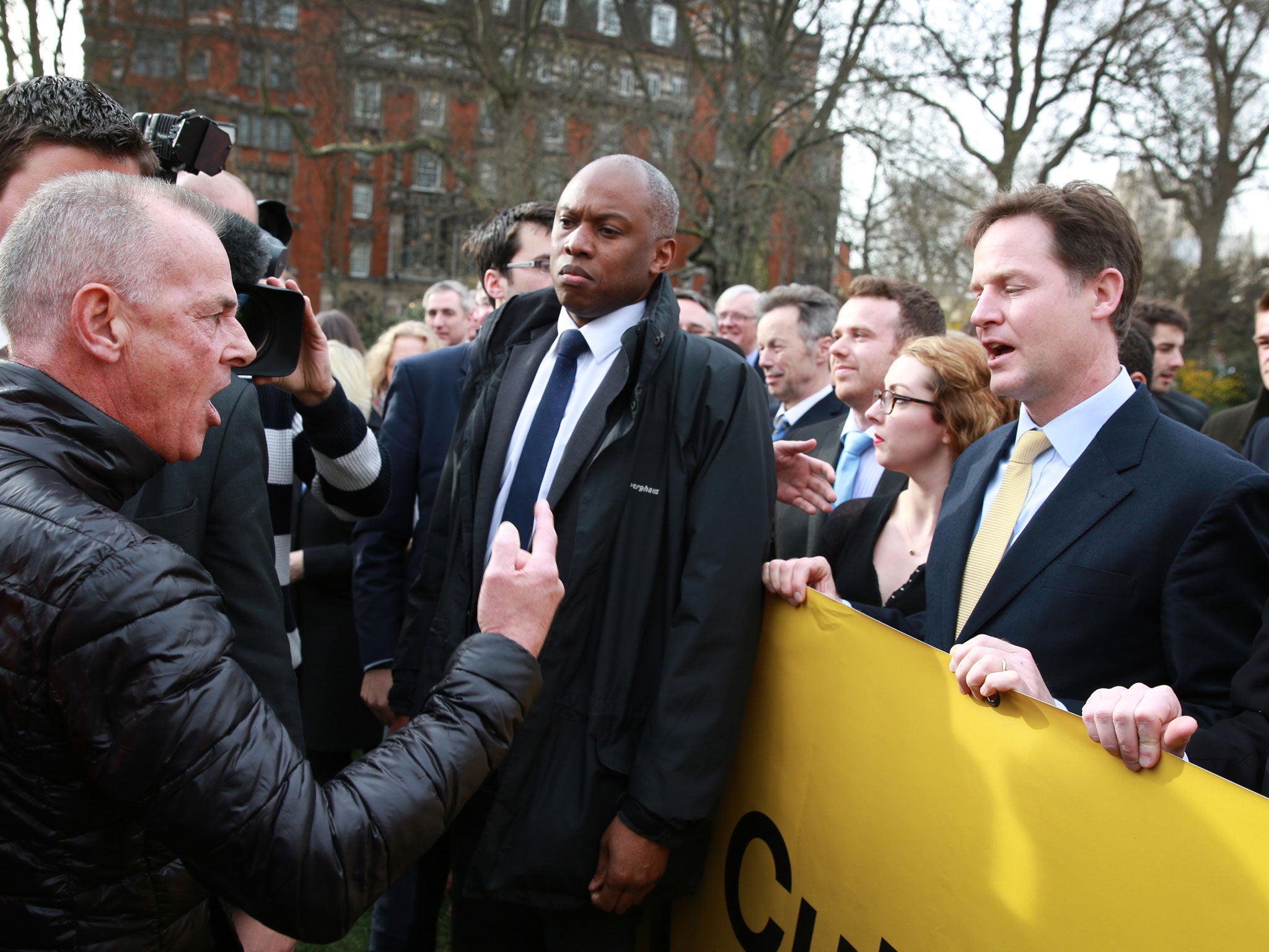 Protestor Bill Maloney (L) gestures as he shouts at Deputy Prime Minister Nick Clegg (R)