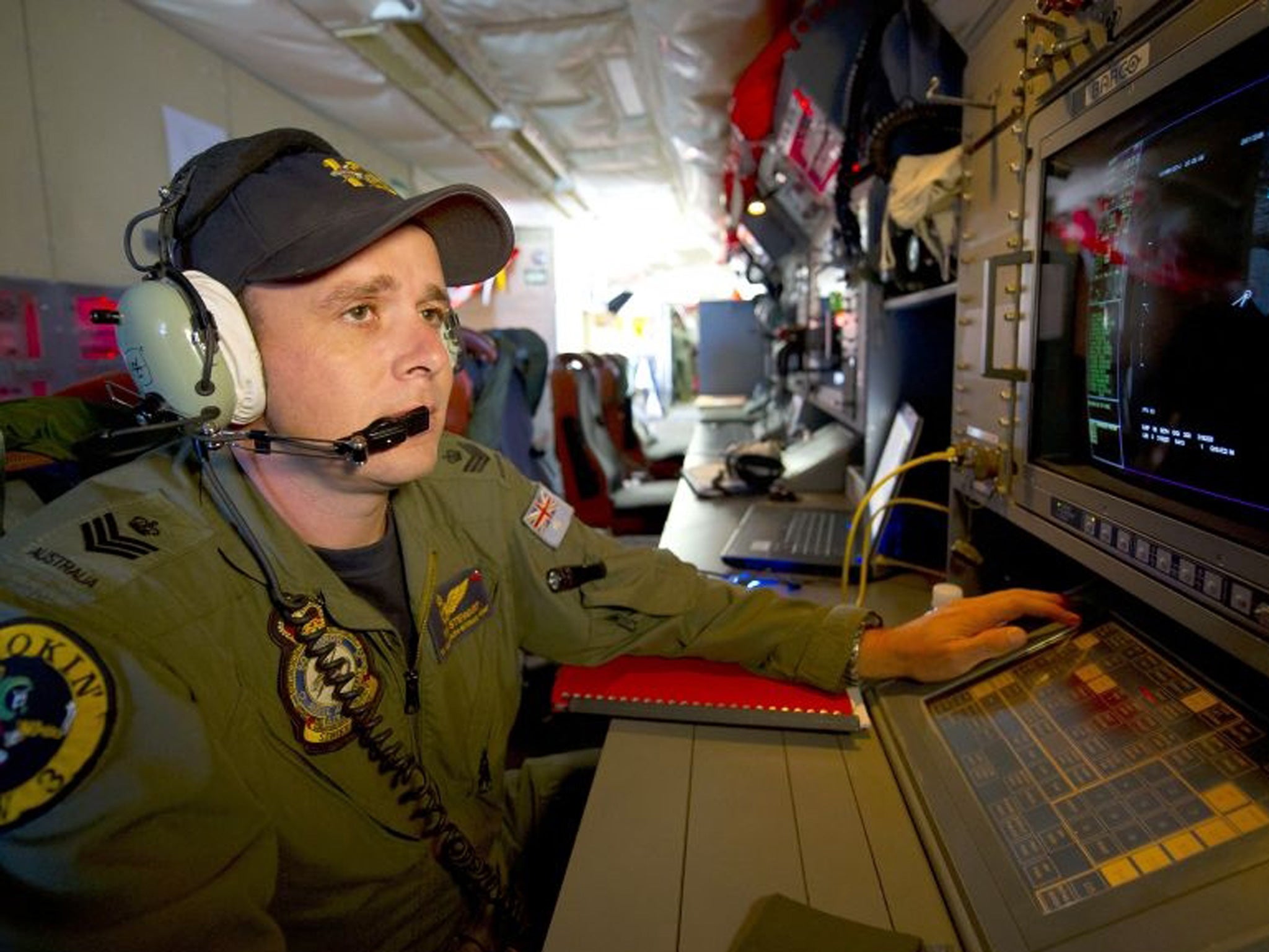 A handout photo taken on 19 March 2014 shows Royal Australian Air Force Airborne Electronics Analyst Flight Sergeant Tom Stewart from 10 Squadron watching a radar screen for signs of debris on board an AP-3C Orion over the Southern Indian Ocean during the