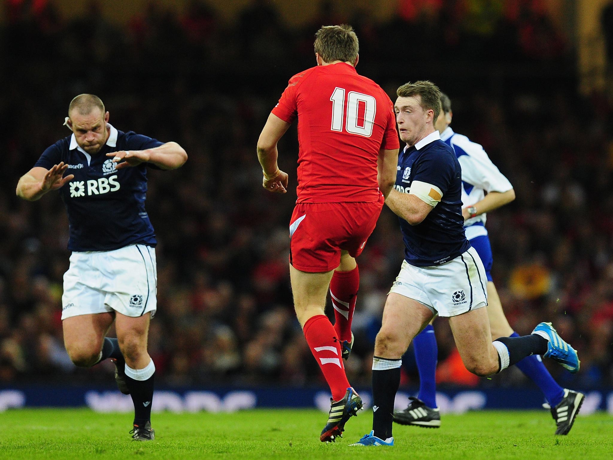 Stuart Hogg (R) makes a late charge on Wales fly-half Dan Biggar (C) to earn himself a red card and subsequent three week ban