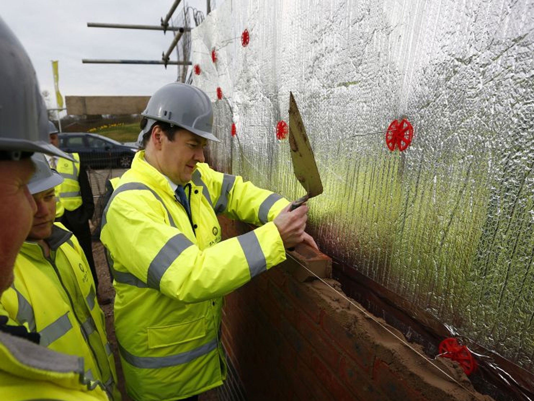 Chancellor of the Exchequer George Osborne lays a brick during a visit to a Barratt Homes building site in Nuneaton, the day after he said in his annual budget that the government would extend the equity loan portion of the Help to Buy scheme for four yea
