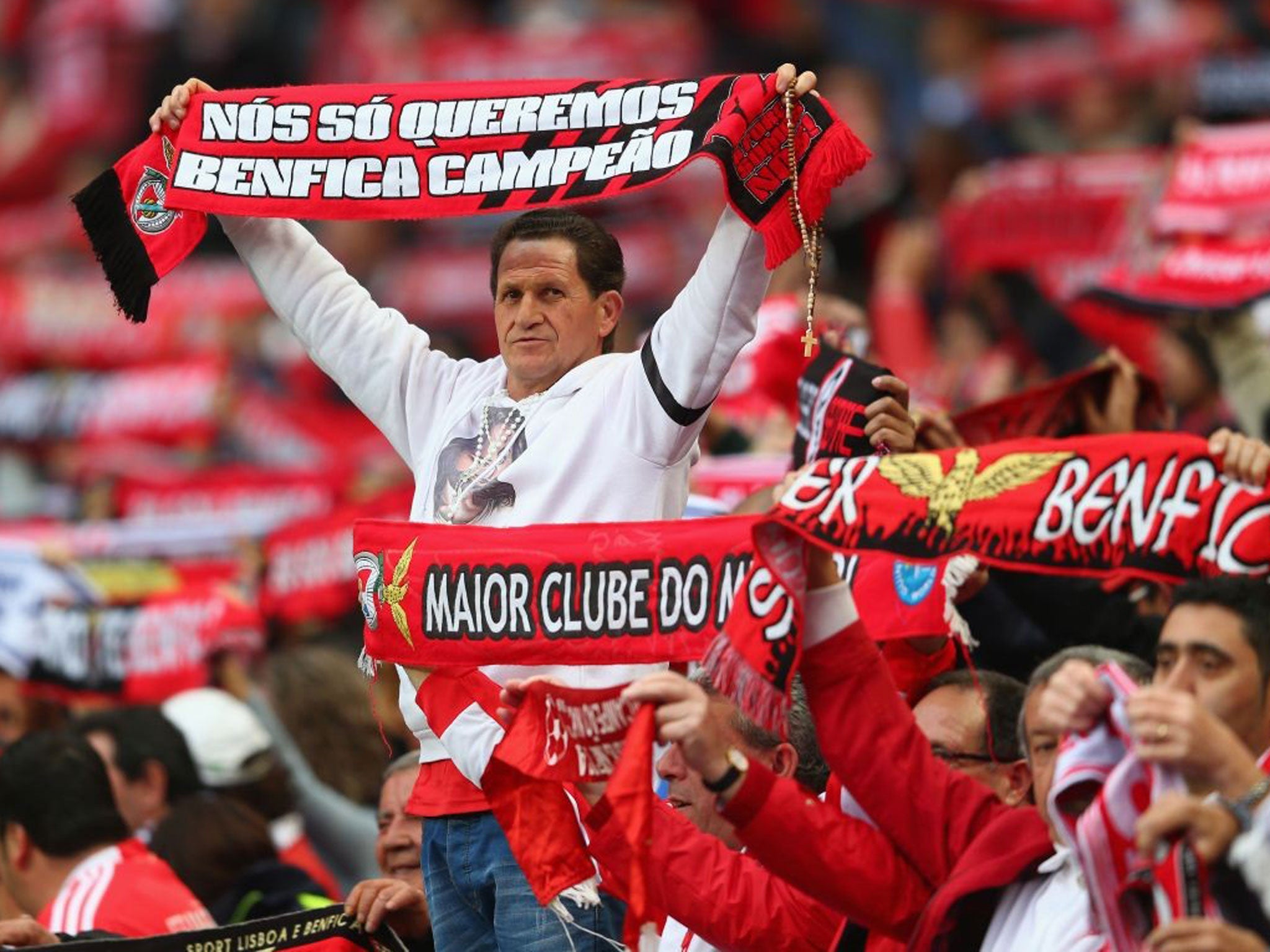 A supporter of SL Benfica looks on amongst a forest of scarves