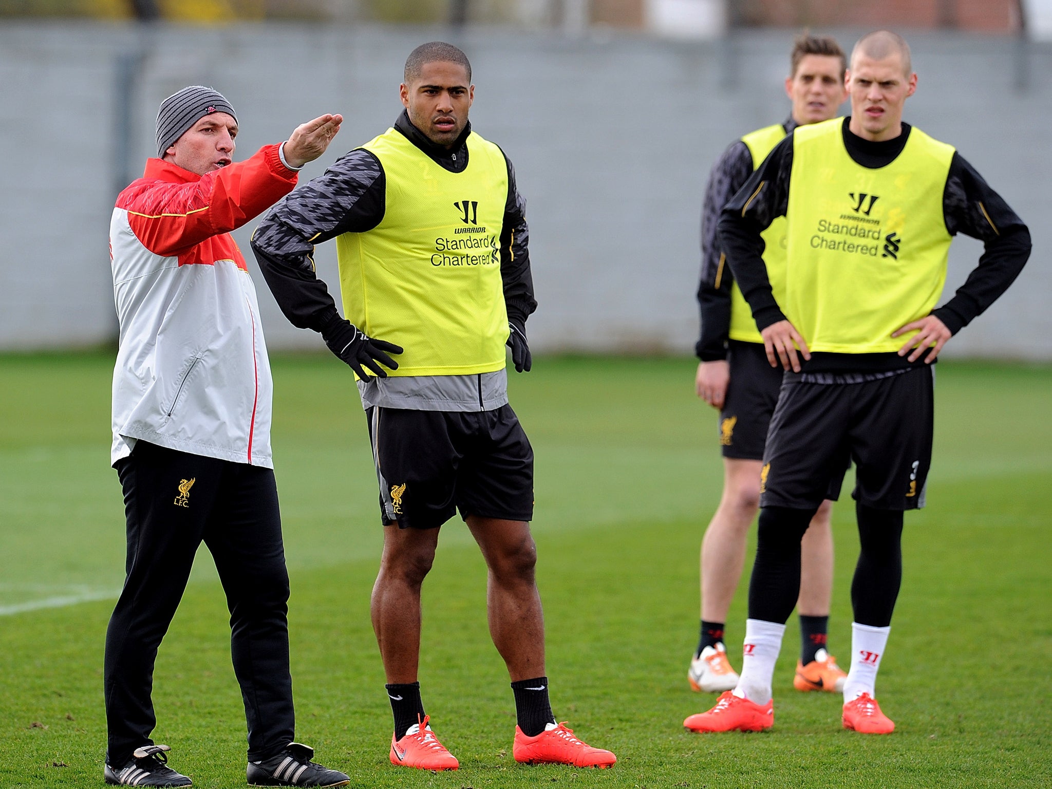 Brendan Rodgers speaks with Liverpool defenders Glen Johnson and Martin Skrrtel