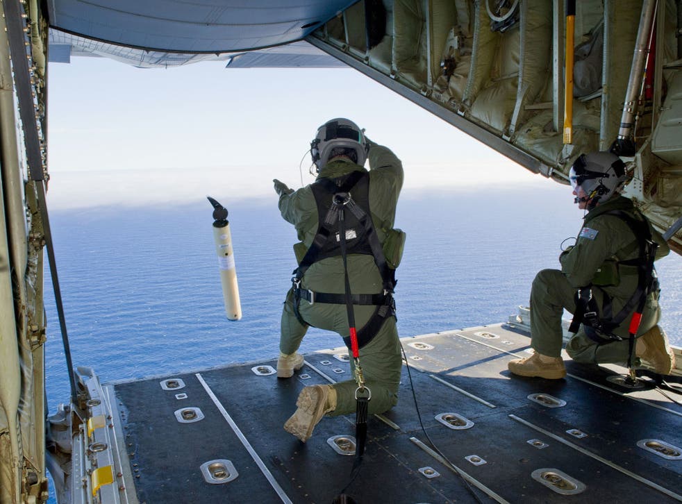 Royal Australian Air Force Loadmasters, Sergeant Adam Roberts (L) and Flight Sergeant John Mancey (R), preparing to launch a Self Locating Data Marker Buoy from a C-130J Hercules aircraft in the southern Indian Ocean as part of the Australian Defence Forc