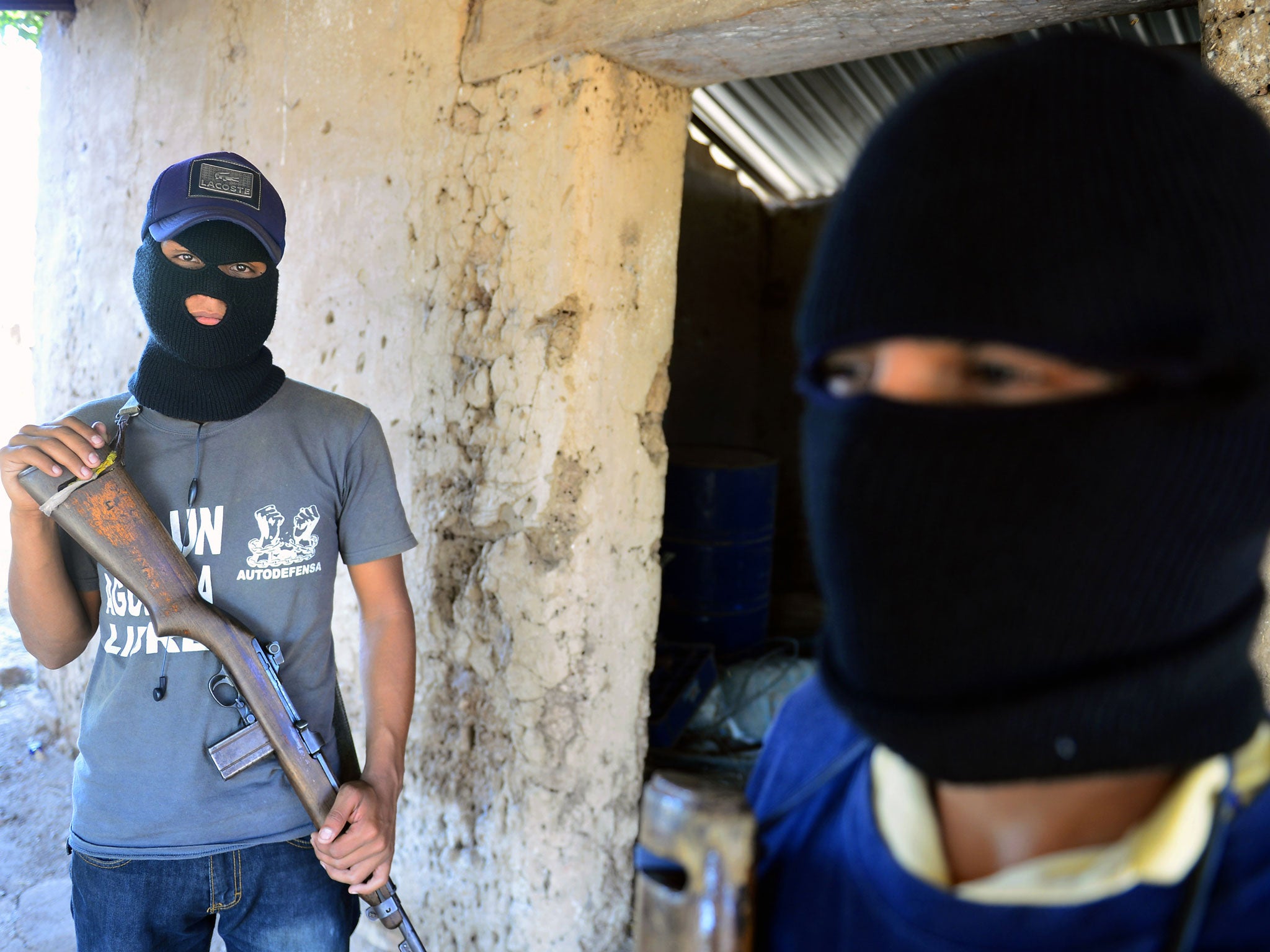 Two former informants of the Templar Knights drug cartel pose in Michoacan state, Mexico