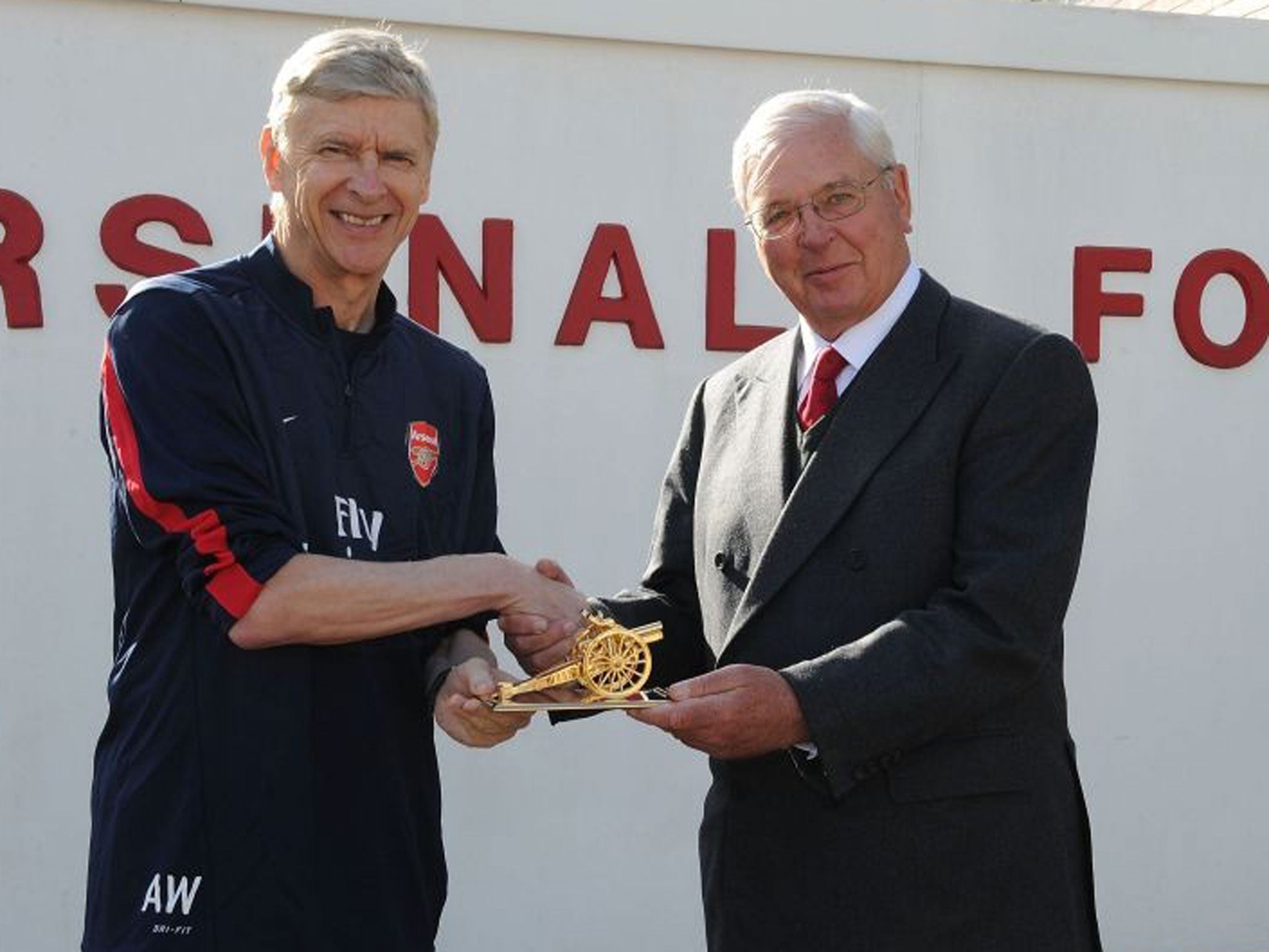 Chairman Sir Chips Keswick (right) presents Arsene Wenger with a gold canon to commemorate his 1000th game as Arsenal manager in March