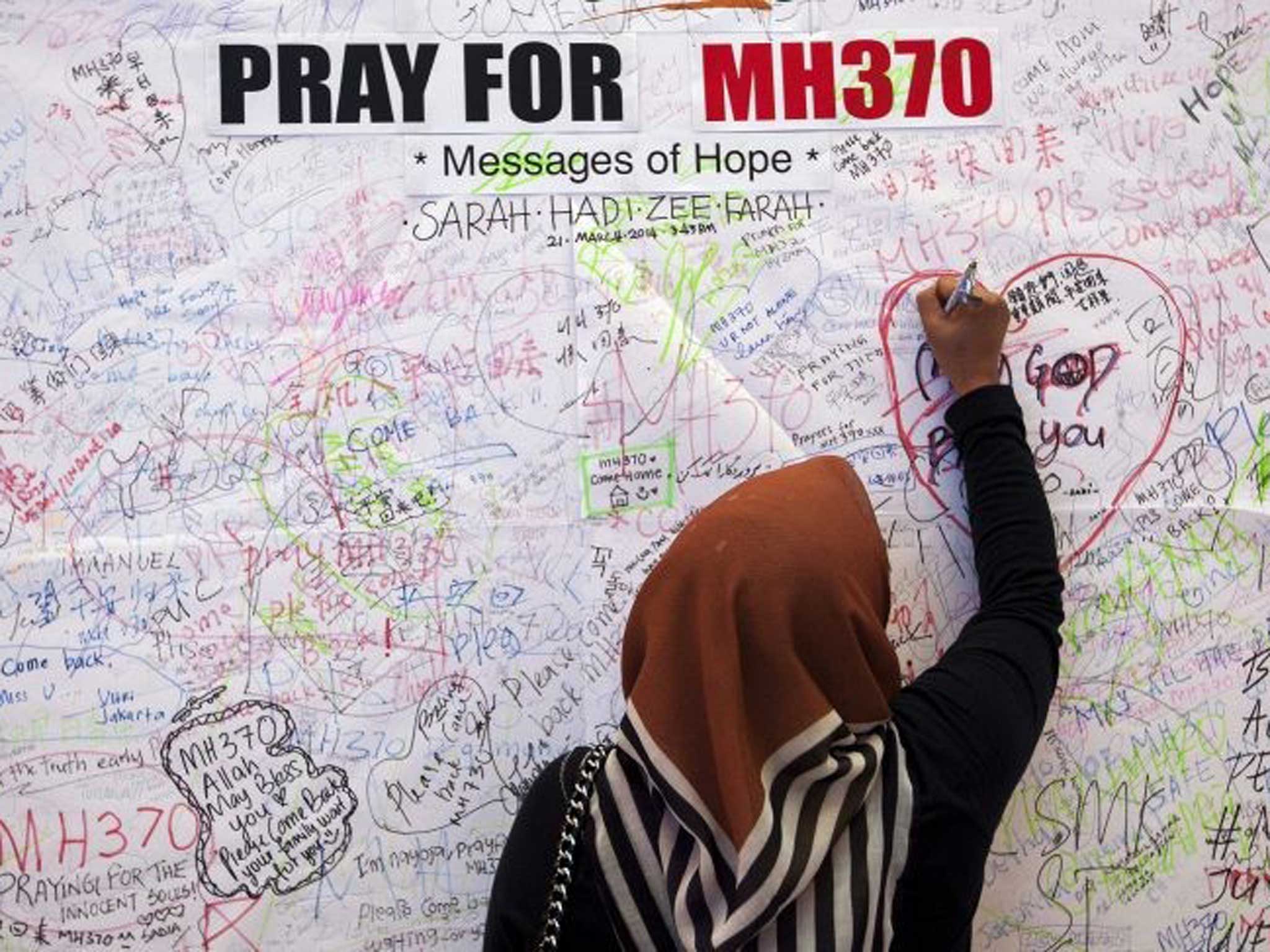 keeping faith: A visitor writes a message of support in Kuala Lumpur