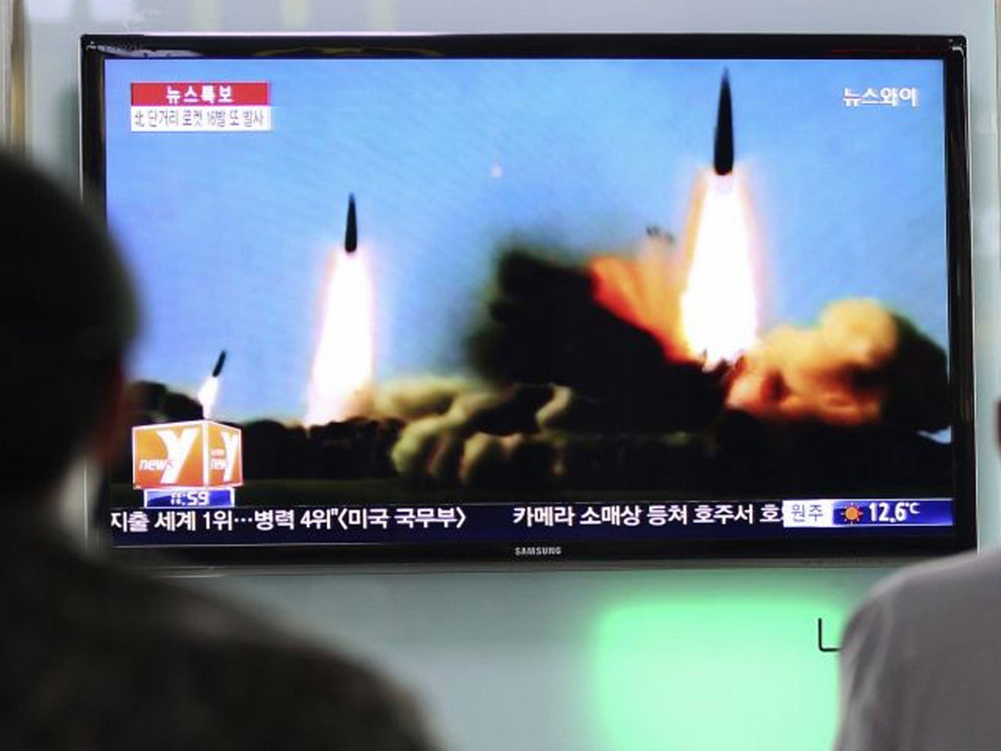 People in Seoul watch a news programme showing rockets launched by Pyongyang