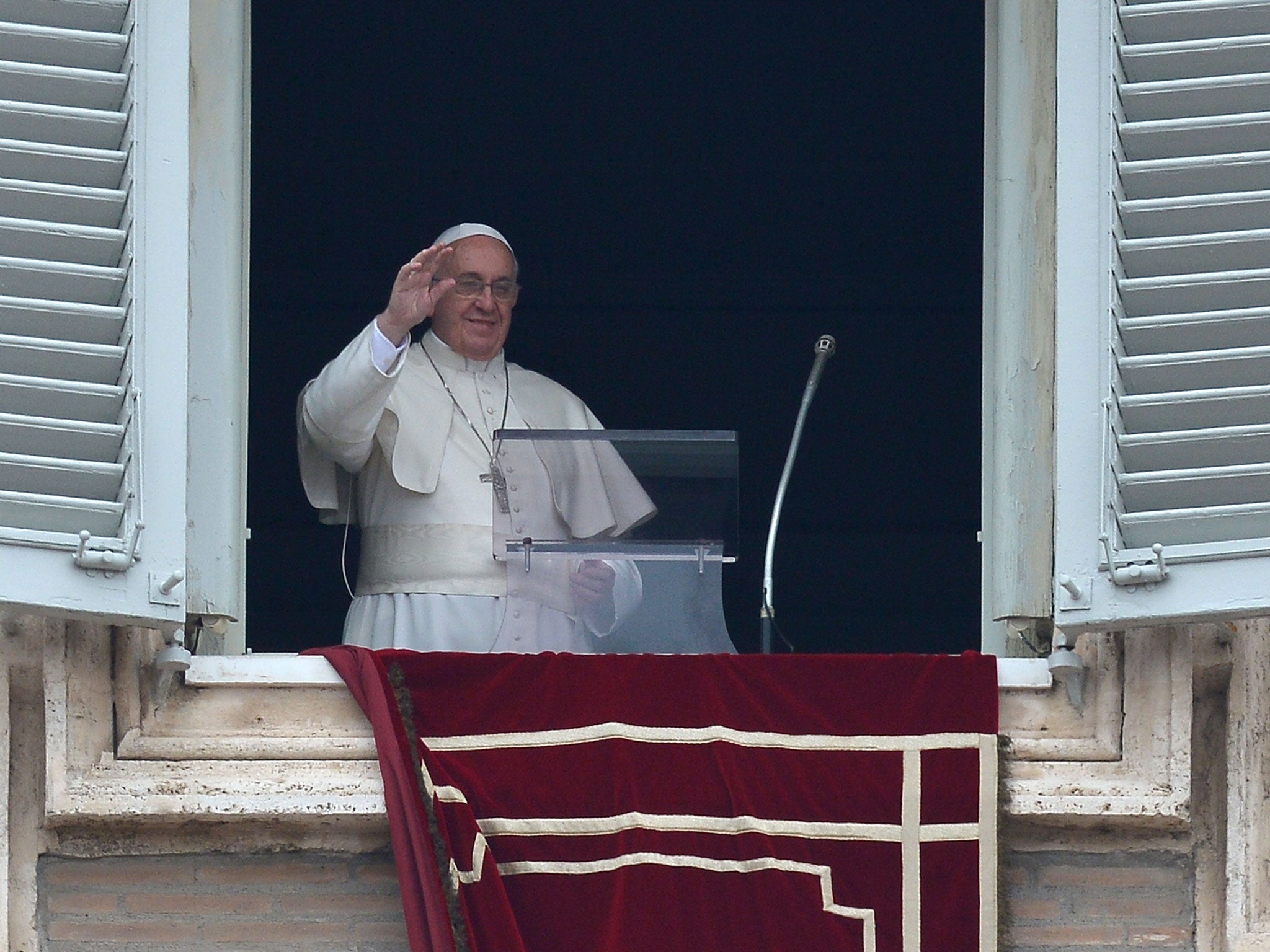 Pope Francis addresses the crowd from his private apartments during his Sunday's Angelus noon prayer at St Peter's square on 23 March