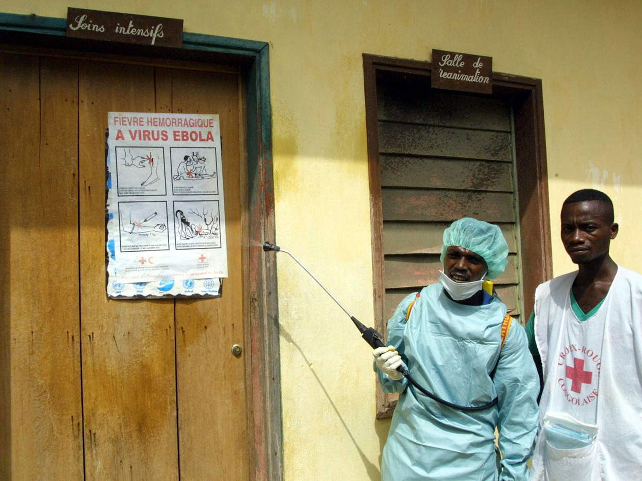 This picture taken on March 9, 2003 shows International Red Cross workers spraying disinfectant around the Intensive Care room at Kelle hospital, northwestern Congo, where an Ebola fever infected patient lies. An Ebola epidemic which has already killed do