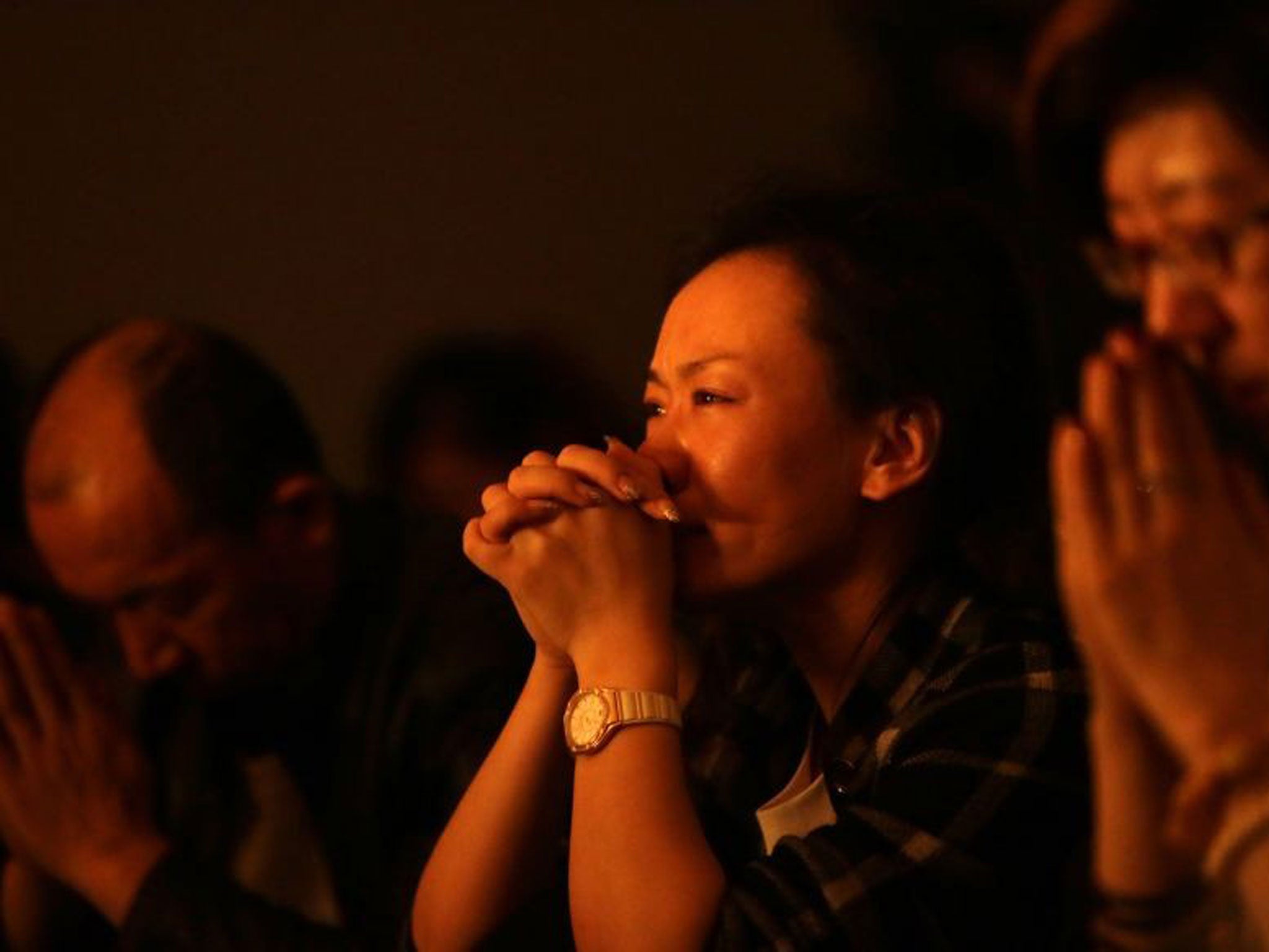 Relatives of passengers onboard Malaysia Airlines Flight MH370 pray at a praying room at Lido Hotel in Beijing