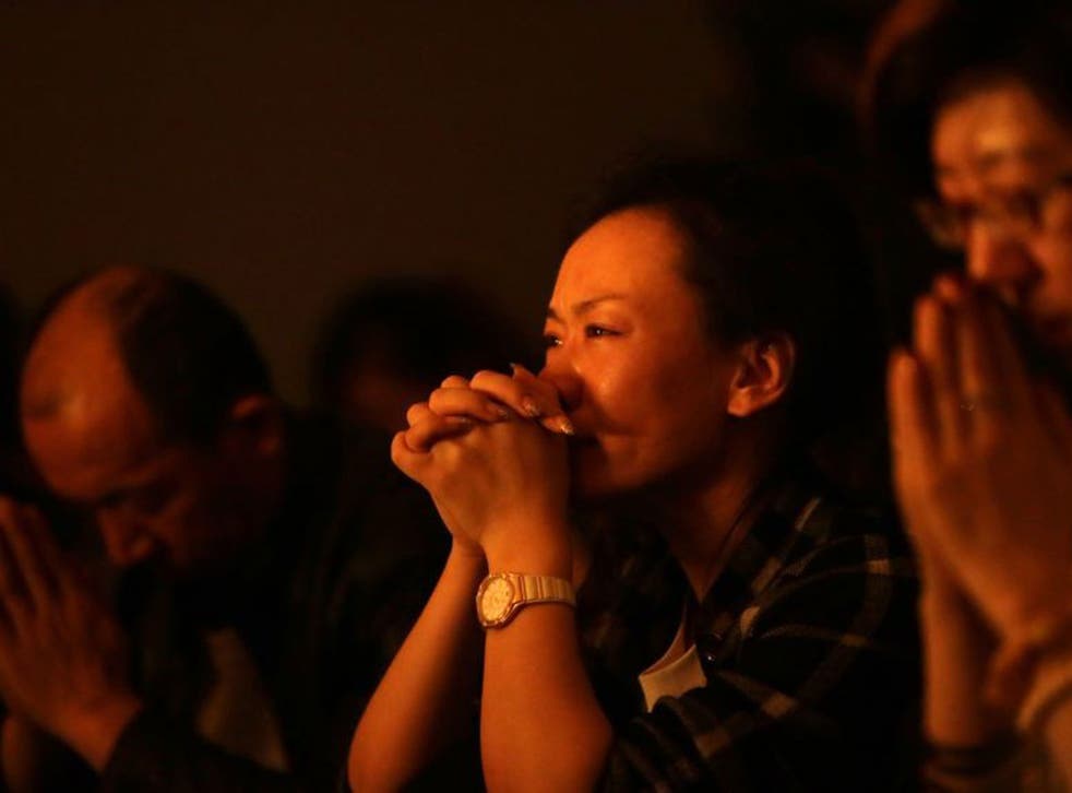 Relatives of passengers onboard Malaysia Airlines Flight MH370 pray at a praying room at Lido Hotel in Beijing 